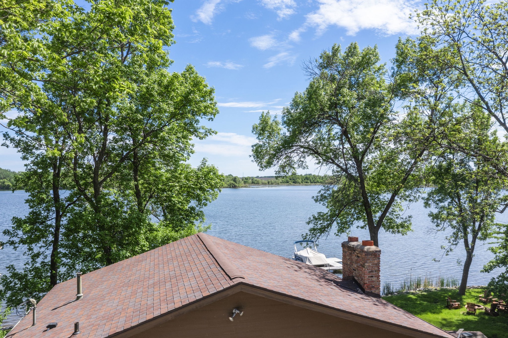 Waterfront vacation rental set along a serene lake with lush tree cover and a private dock for boating and lakeside relaxation.
