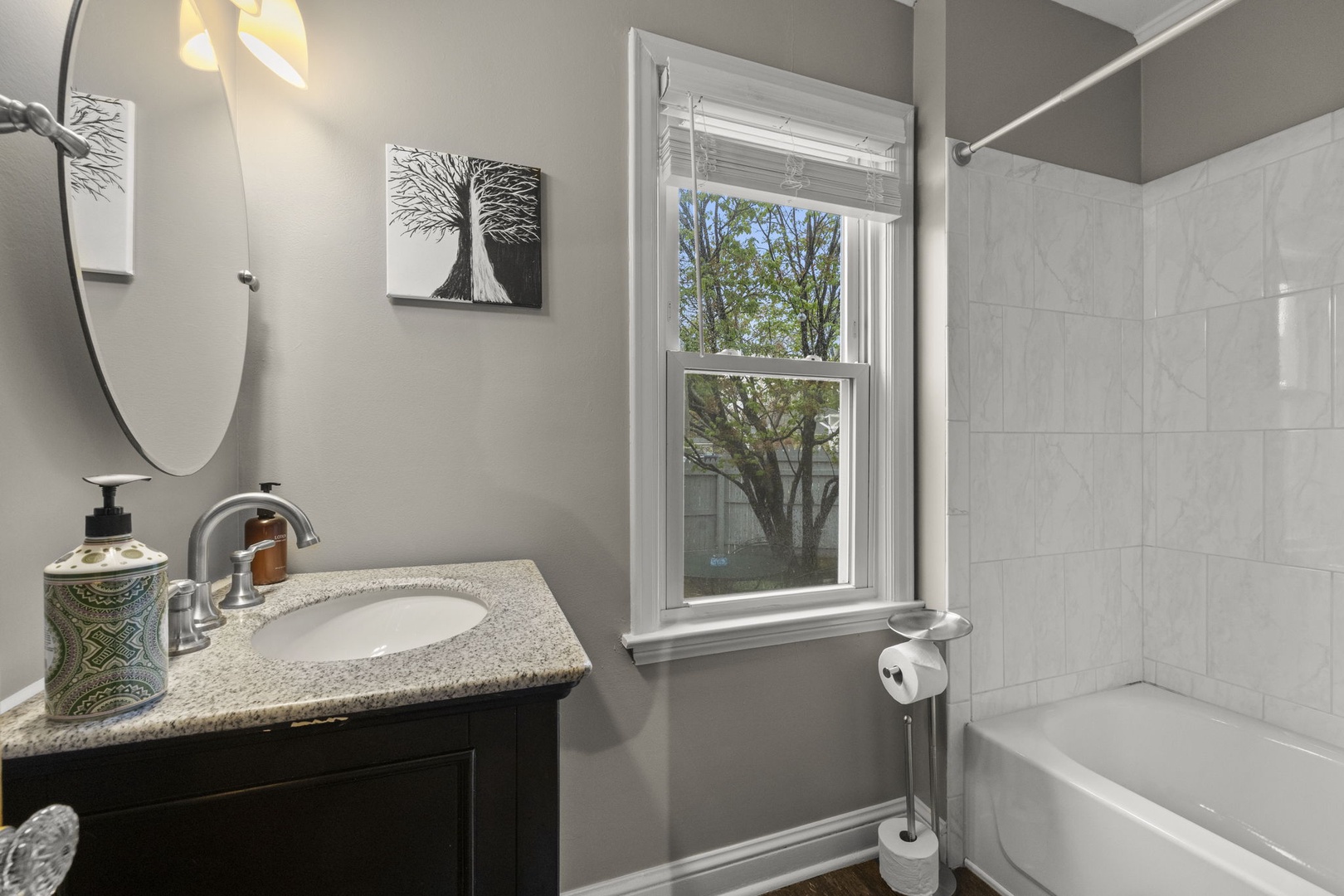 Refresh in your stylish bathroom with modern fixtures, natural light, and a sleek tub-shower combo—a calming space designed for your comfort and convenience.