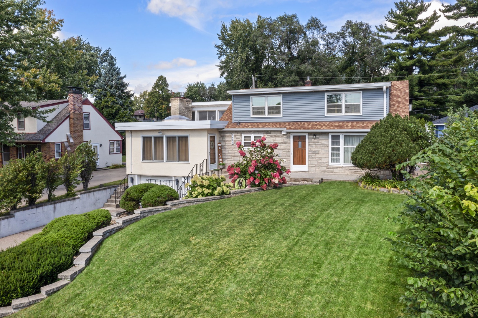 A charming multi-level home nestled in a peaceful residential neighborhood, featuring beautiful landscaped grounds and mature trees surrounding the property.