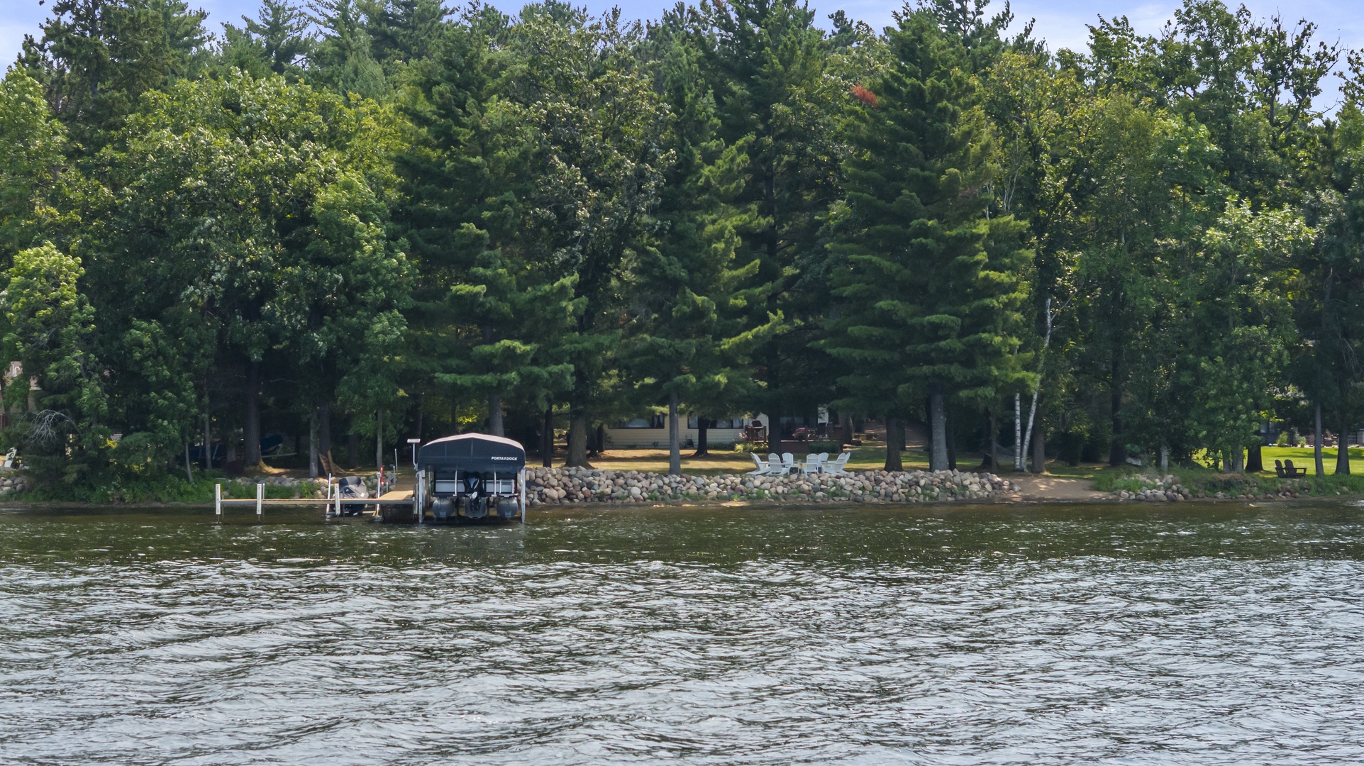 This lakefront property is nestled among mature trees with private dock access and a peaceful shoreline setting, perfect for your waterside retreat.