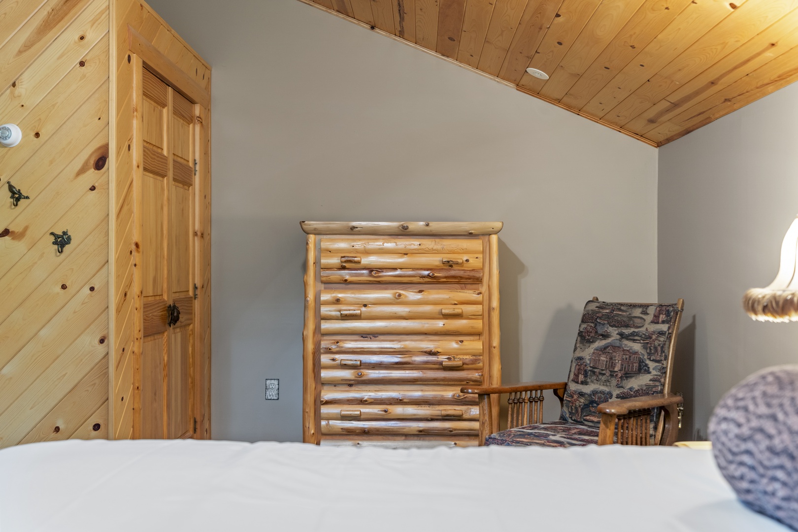 Rustic log furniture and knotty pine accents create a cozy, cabin-inspired retreat where you can unwind surrounded by natural wood charm.