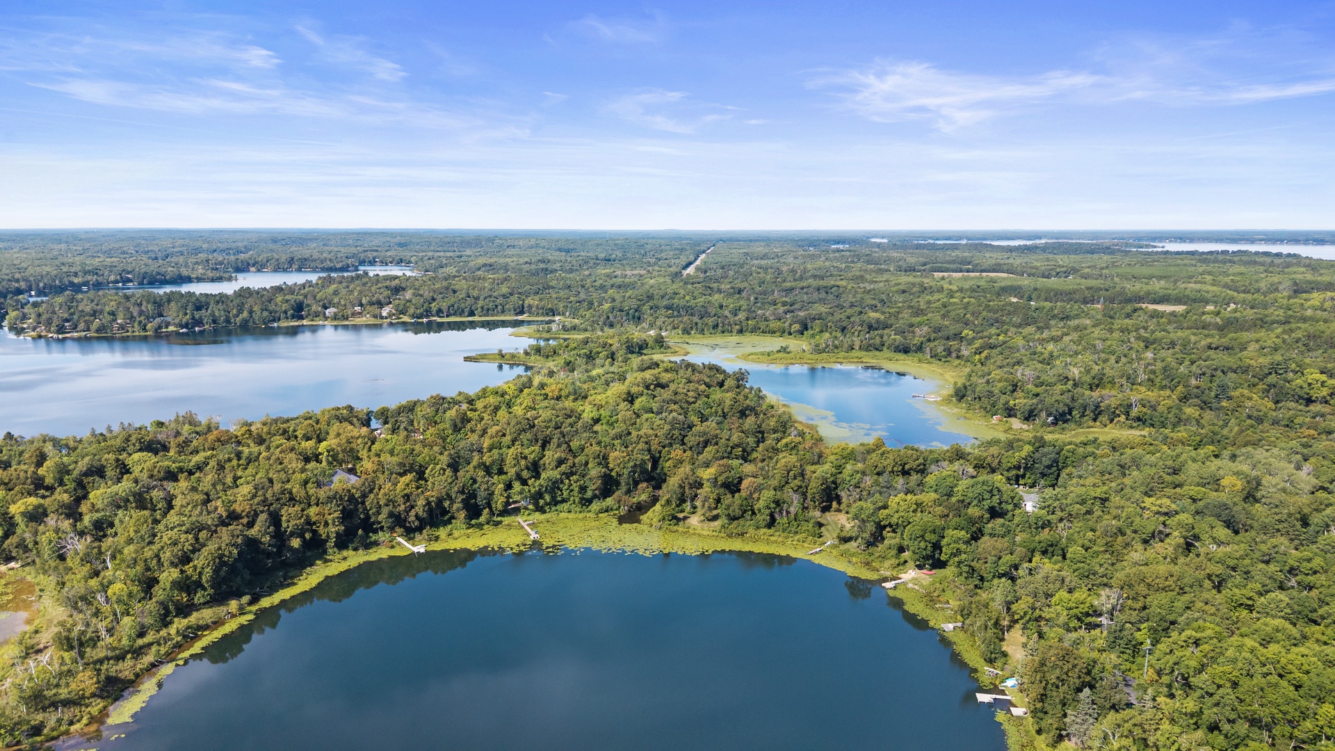 An aerial view showcasing the property's picturesque lakeside location surrounded by lush forests and tranquil waterways—a peaceful retreat immersed in natural beauty.