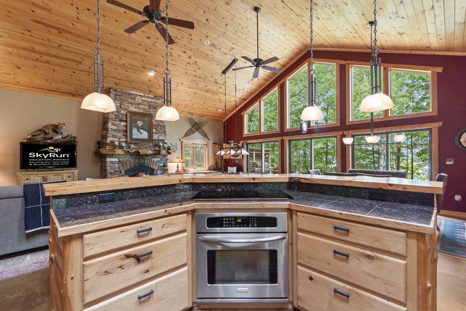 Cook your favorite meals in a warm, wood-wrapped kitchen with high ceilings and natural light streaming through forest views. The open layout keeps you connected to everyone during your stay.