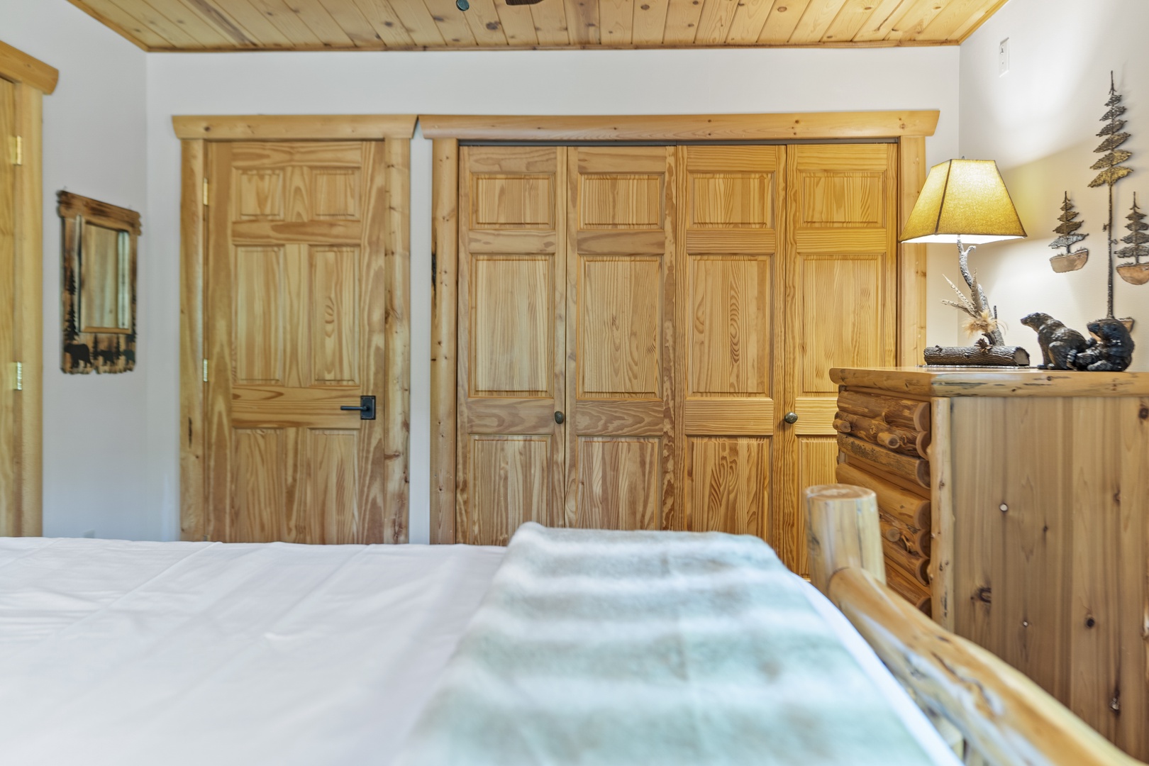 Unwind in this cozy bedroom with warm pine wood finishes, offering ample closet space for your belongings and rustic mountain charm throughout.