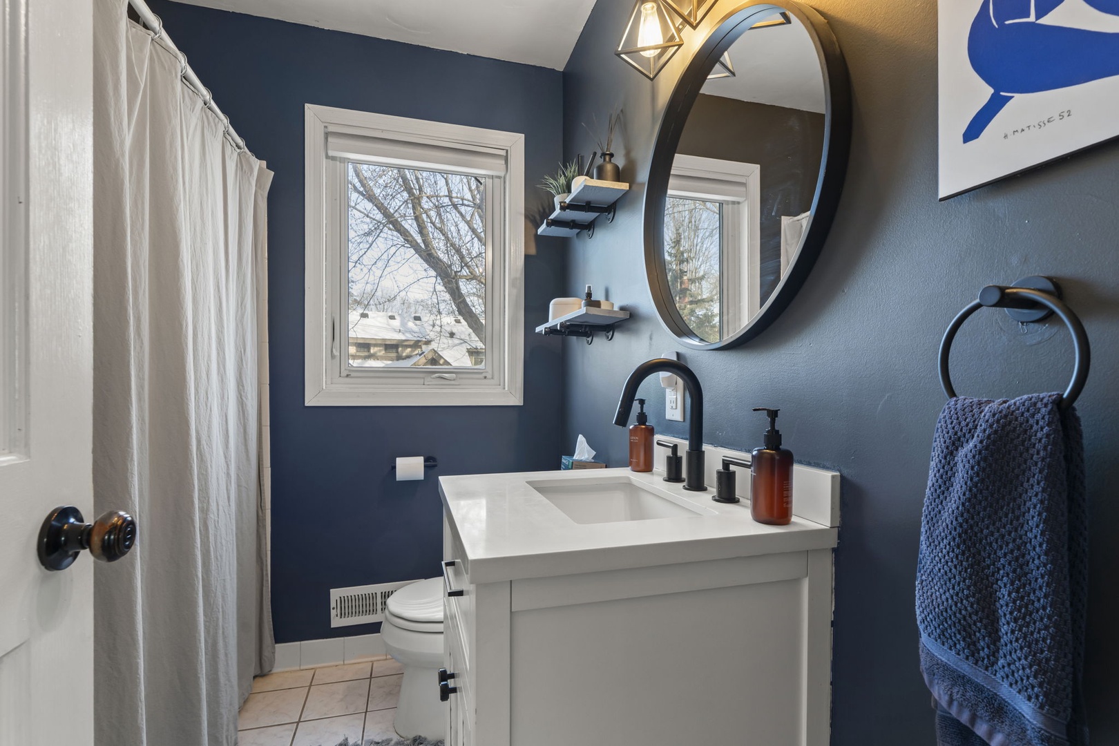 This stylish blue bathroom invites you to refresh with modern amenities and thoughtful touches that make your stay comfortable.