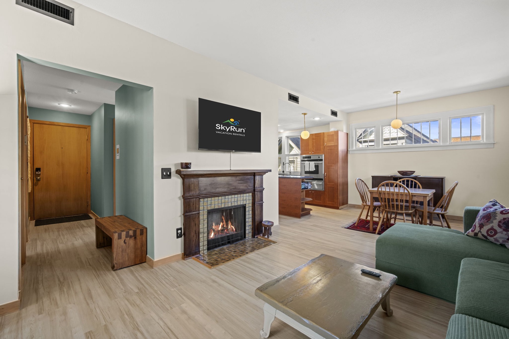 Step into your cozy retreat with warm wood tones, a crackling fireplace, and an open layout connecting the living area to your fully equipped kitchen and dining space—perfect for relaxing after a day of adventure.