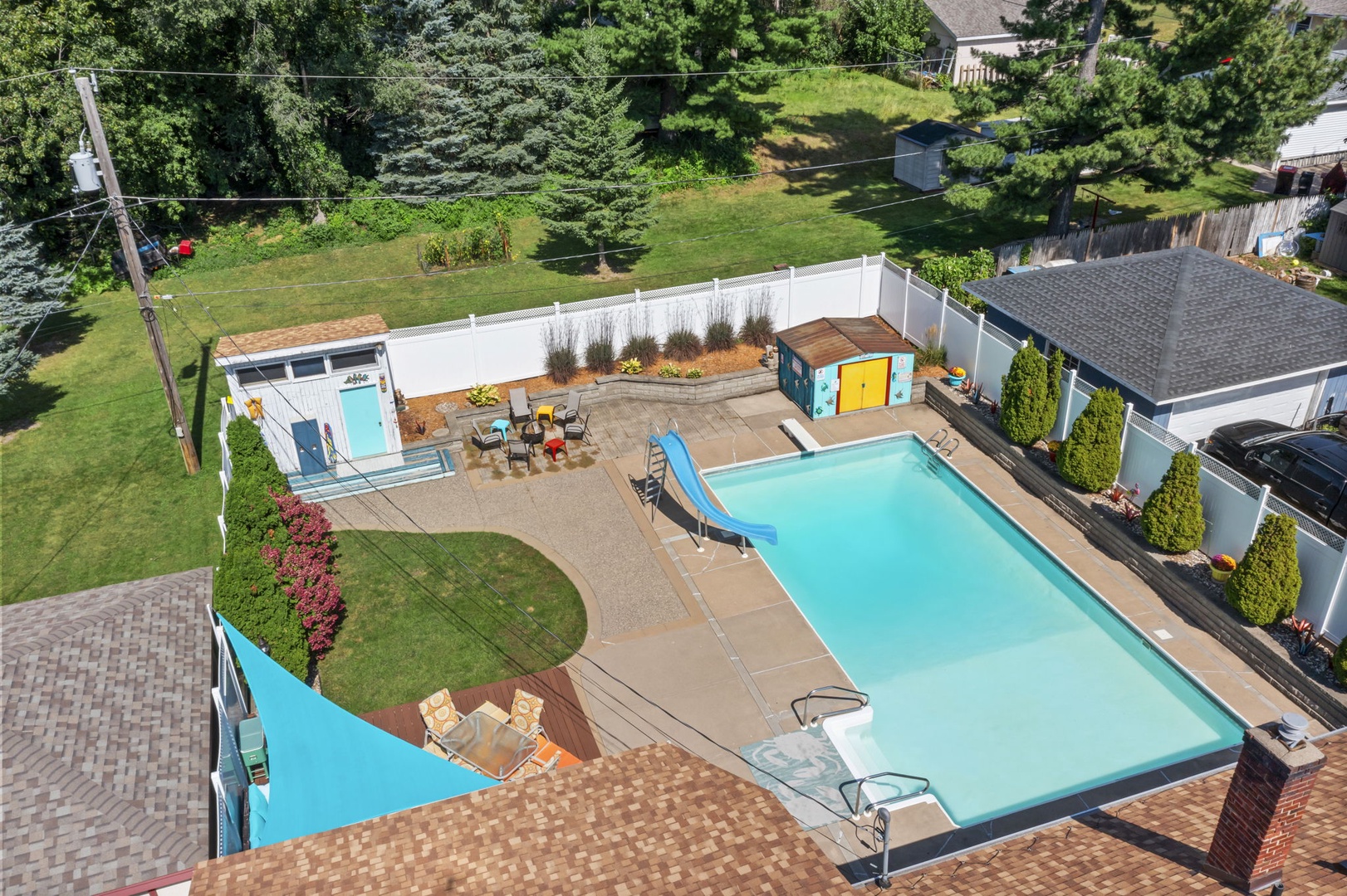 Aerial view of property featuring a spacious backyard area with deck seating, outdoor amenities, and mature landscaping. Pool is not available for guest use per Minnesota state law.