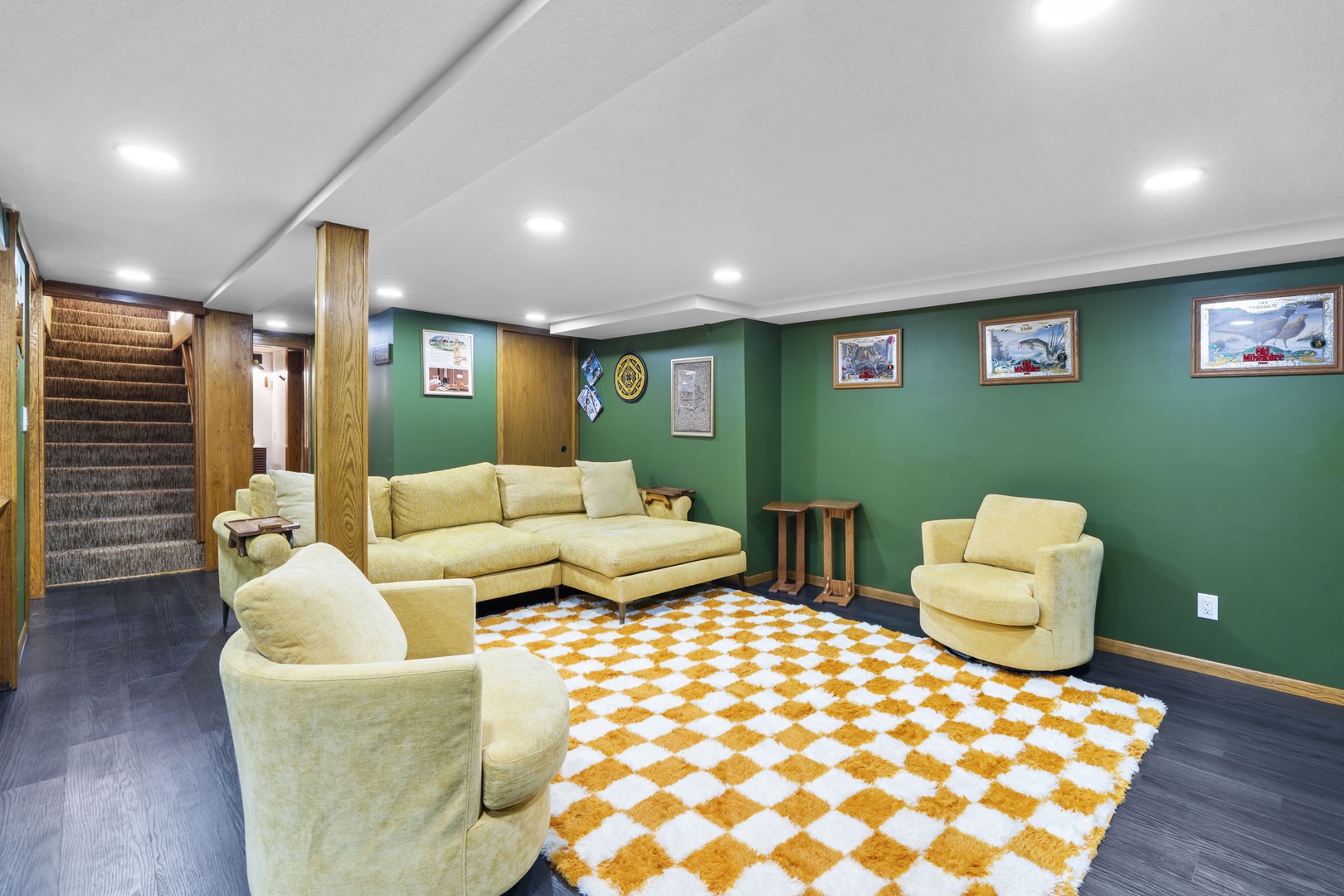 Sink into plush velvet seating in your private basement lounge, where vibrant green walls and warm wood create the perfect retreat.