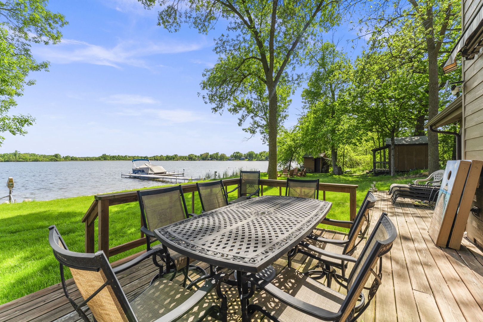 Relax at your private lakefront deck with sweeping water views, lush lawns, and towering shade trees—a peaceful retreat for morning coffee or evening gatherings by the shore.
