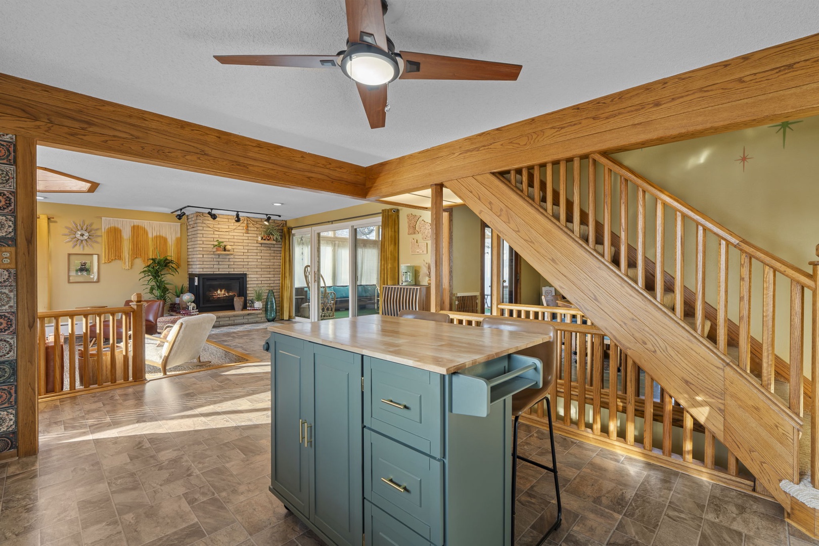 Your open-concept living space features warm wood accents, a cozy fireplace, and charming kitchen island perfect for gathering.