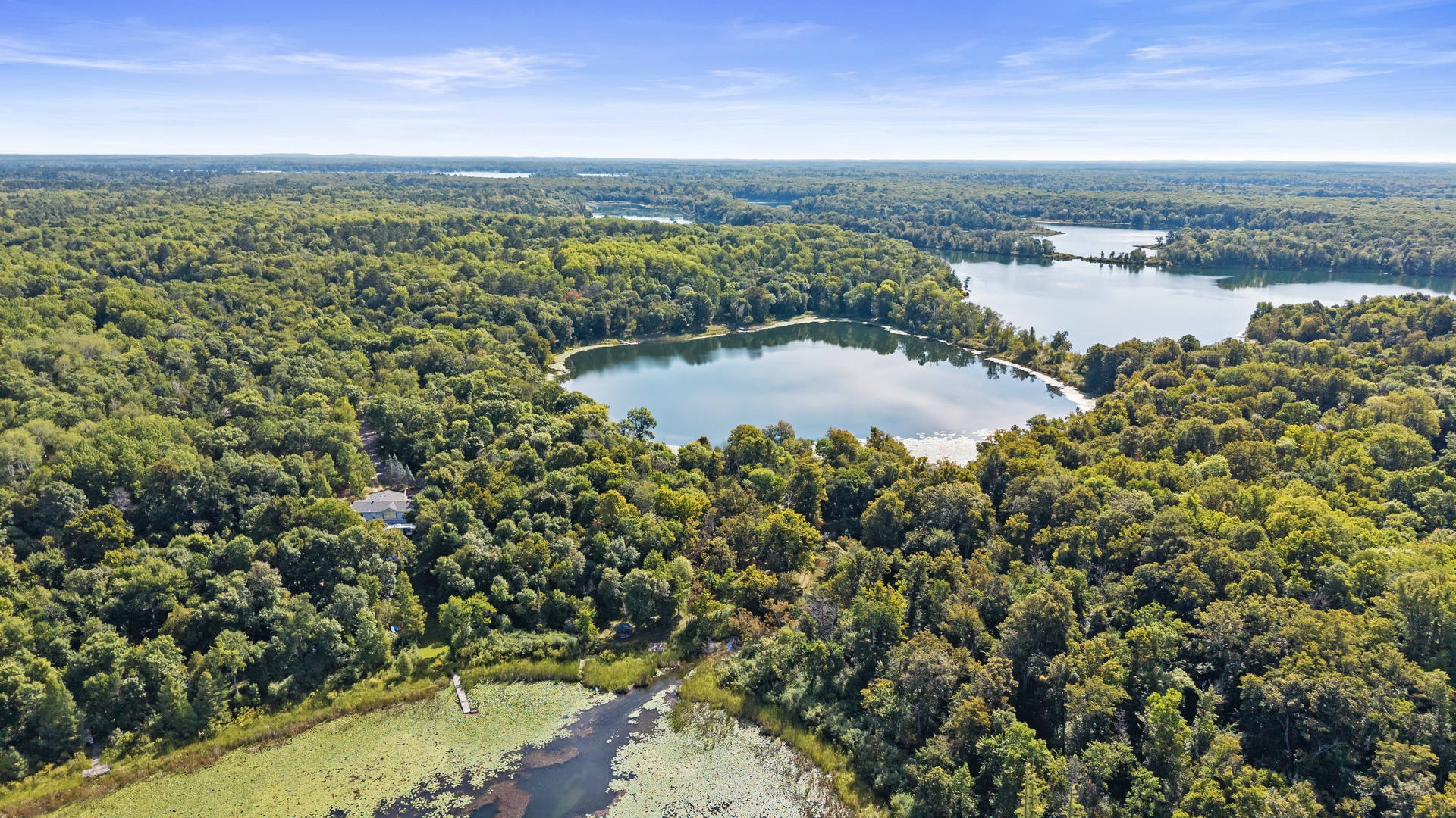 Aerial view showcasing the pristine lakes and lush forest landscape surrounding the property, offering a serene natural setting for your getaway.