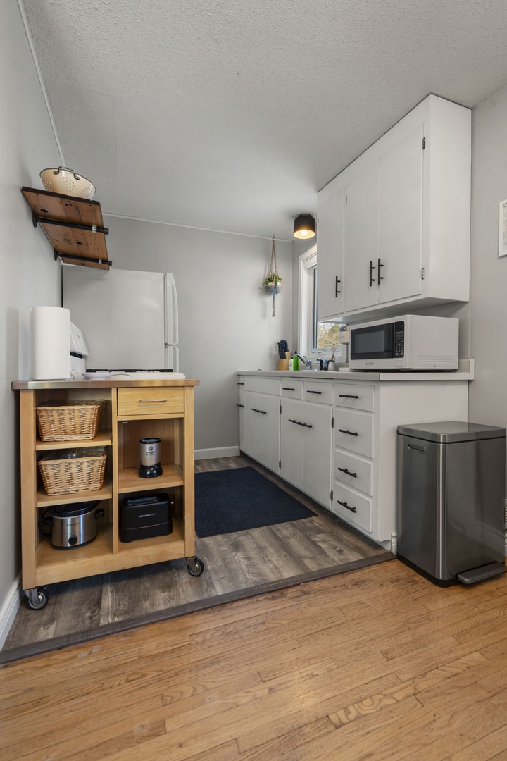 Your fully equipped kitchen features modern appliances and thoughtful storage, including a charming rolling cart for extra prep space.