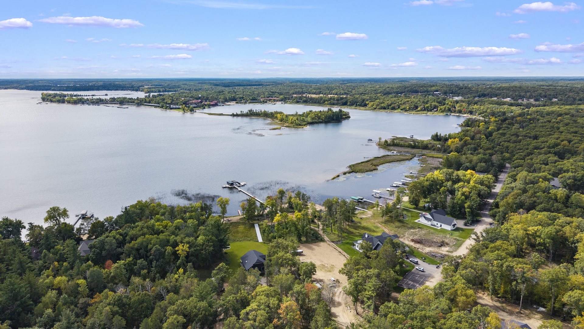 Aerial view of a lakeside property nestled among lush greenery with private docks and peaceful waterfront access.
