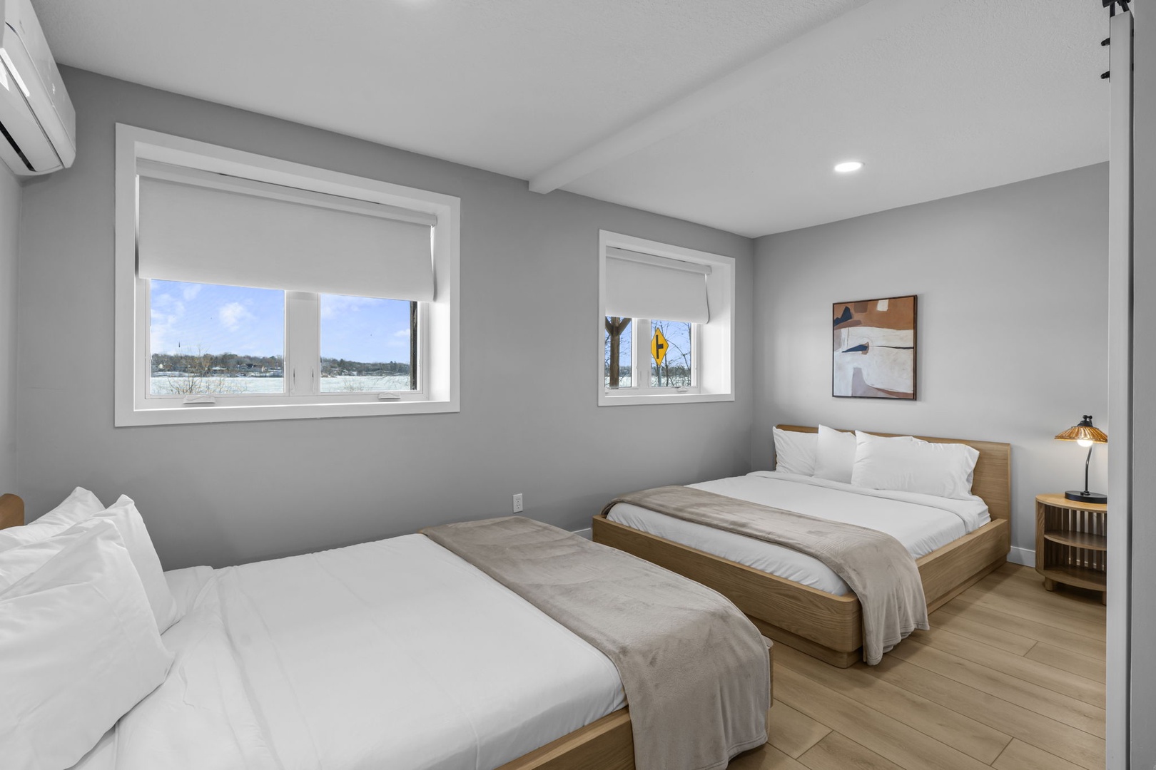 Relax in your modern bedroom featuring two comfortable beds with crisp linens, natural light streaming through windows, and peaceful views to help you unwind.
