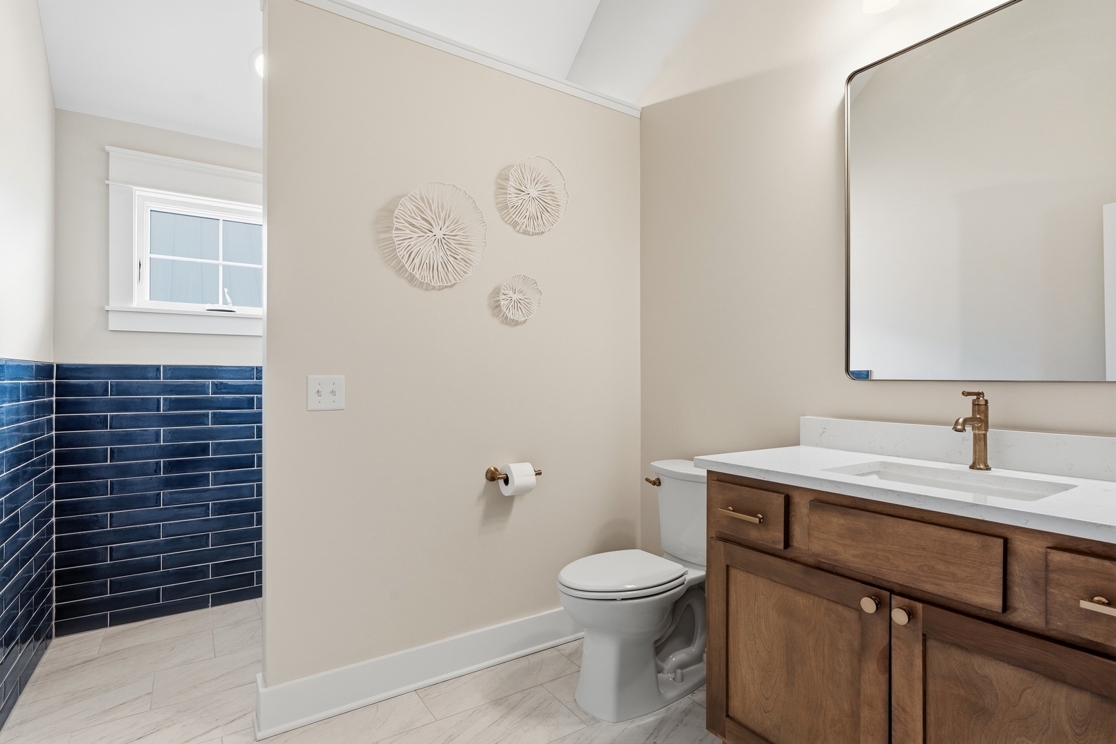 Bathroom vanity with navy blue tile and wood cabinetry
