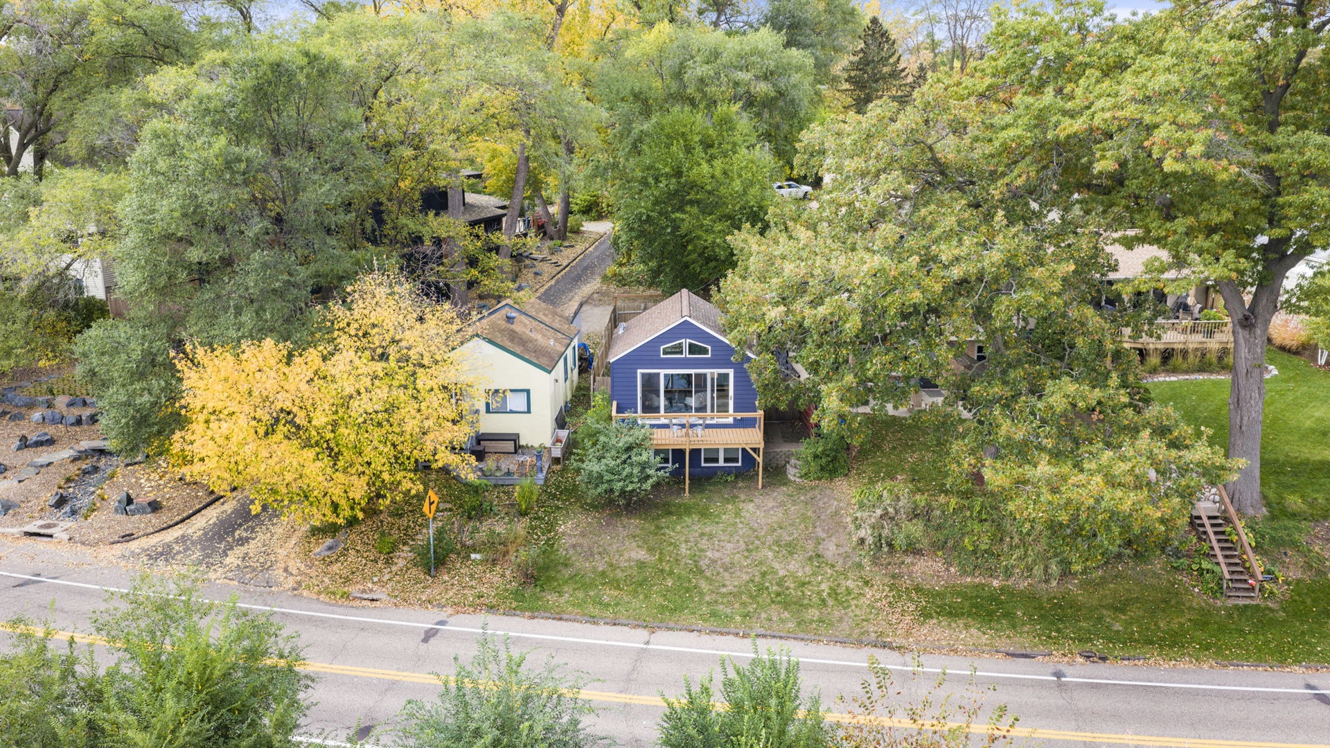 Aerial view of the property nestled among mature trees in a quiet residential neighborhood, perfect for a peaceful getaway.