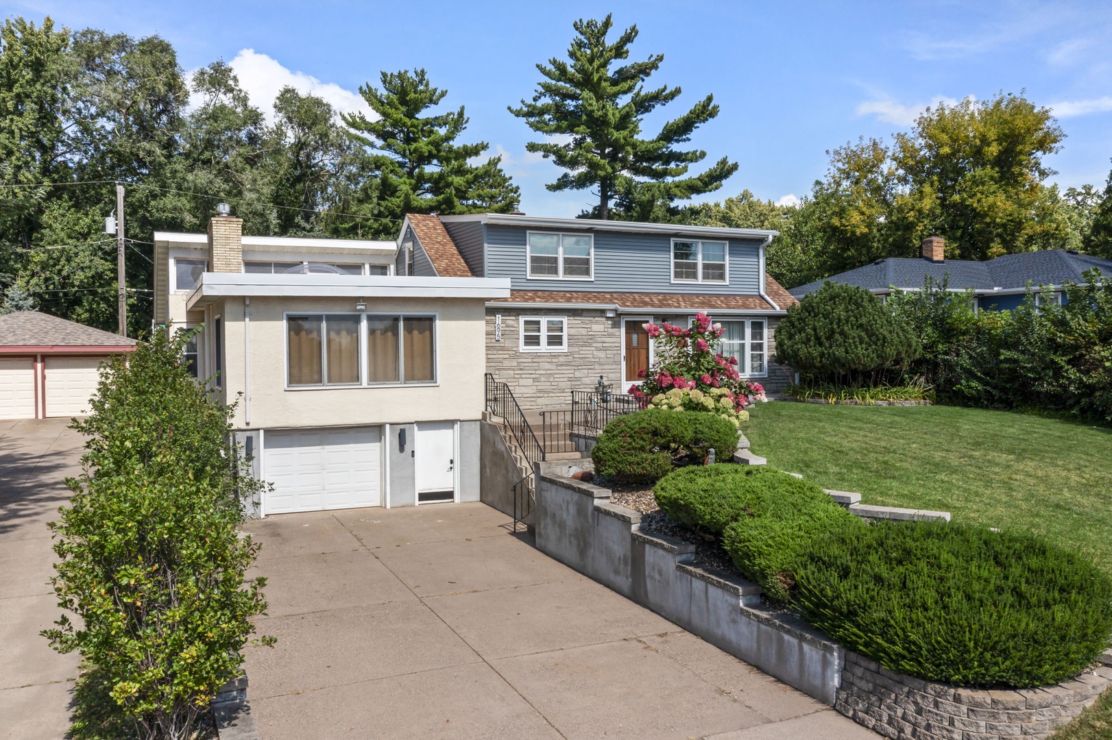 Charming residential property nestled among mature trees with well-maintained landscaping and convenient driveway parking.