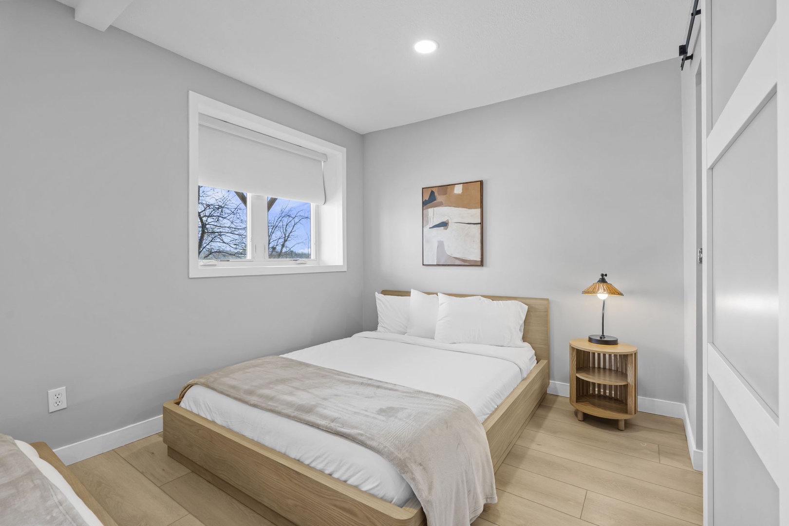 Your serene bedroom features crisp white linens and warm wood accents, creating a peaceful retreat for restful nights.