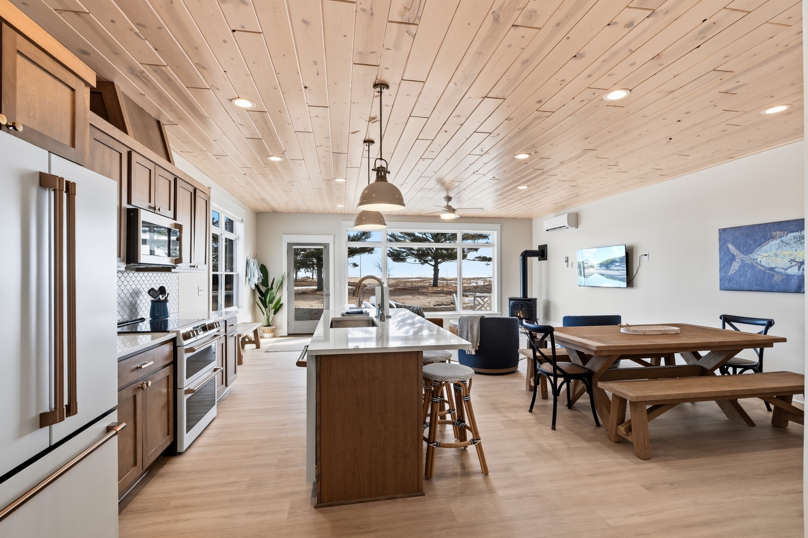 Modern coastal open concept kitchen dining area with island seating and lake views
