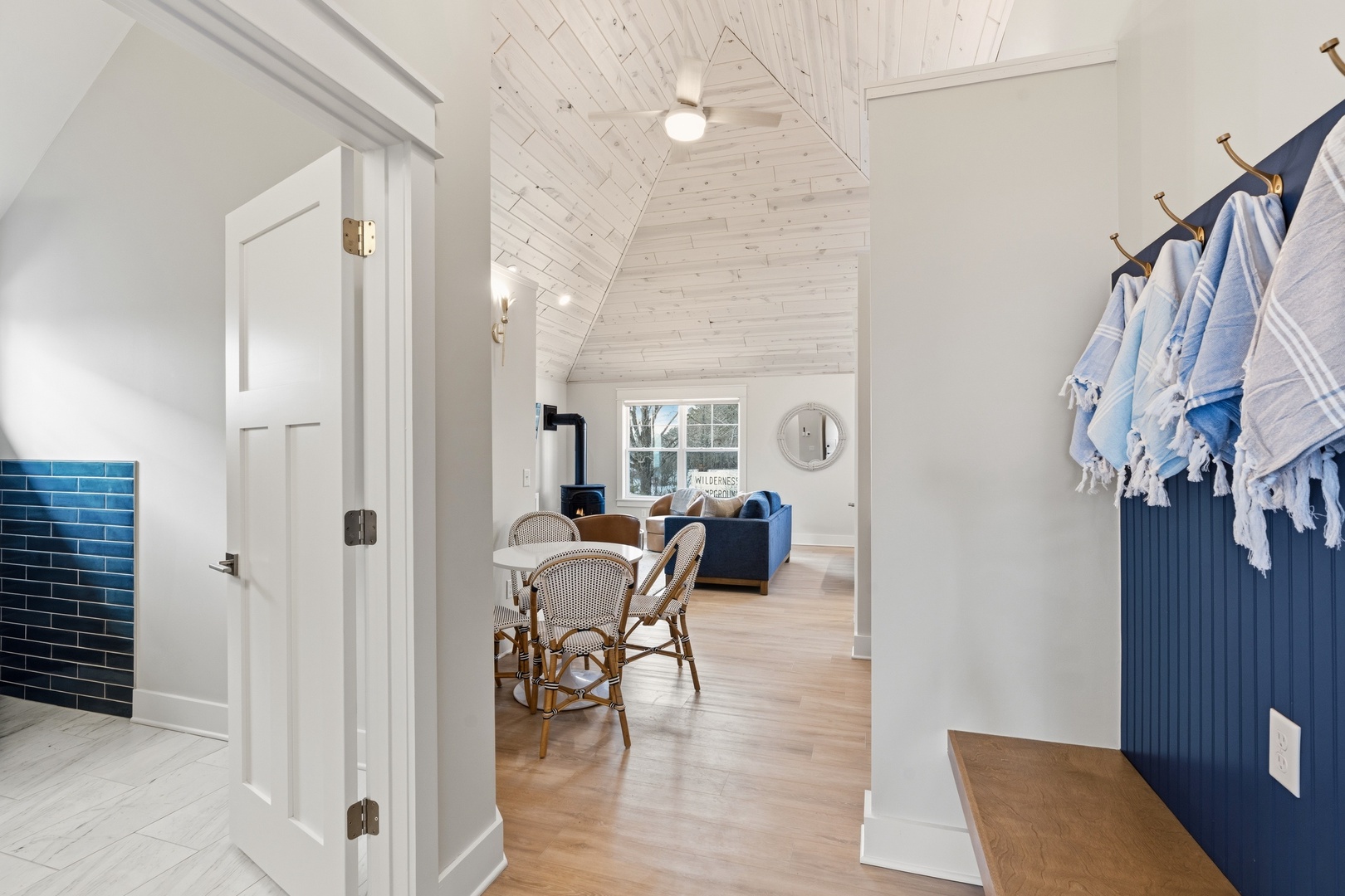 Entryway with hooks and open living area with vaulted shiplap ceiling
