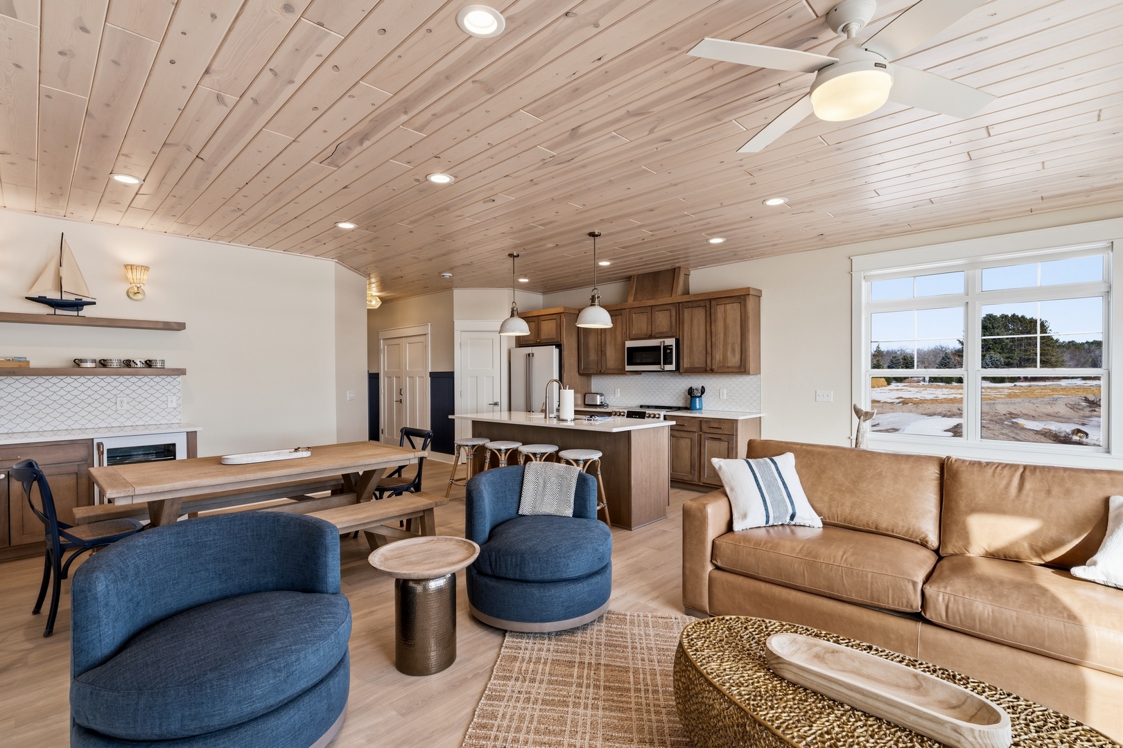 Open floor plan living room kitchen with coastal decor and natural light