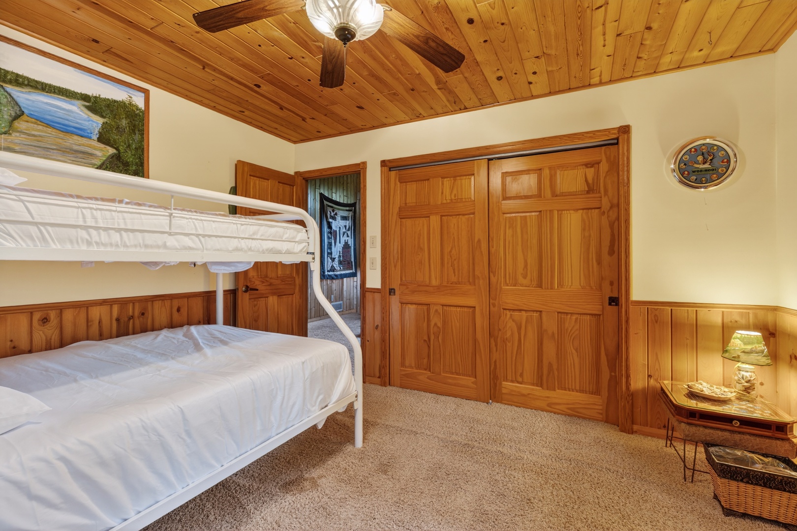 Your cozy bedroom features warm wood accents, ceiling fan comfort, and a convenient bunk bed setup—perfect for families or groups looking to maximize space without sacrificing charm.