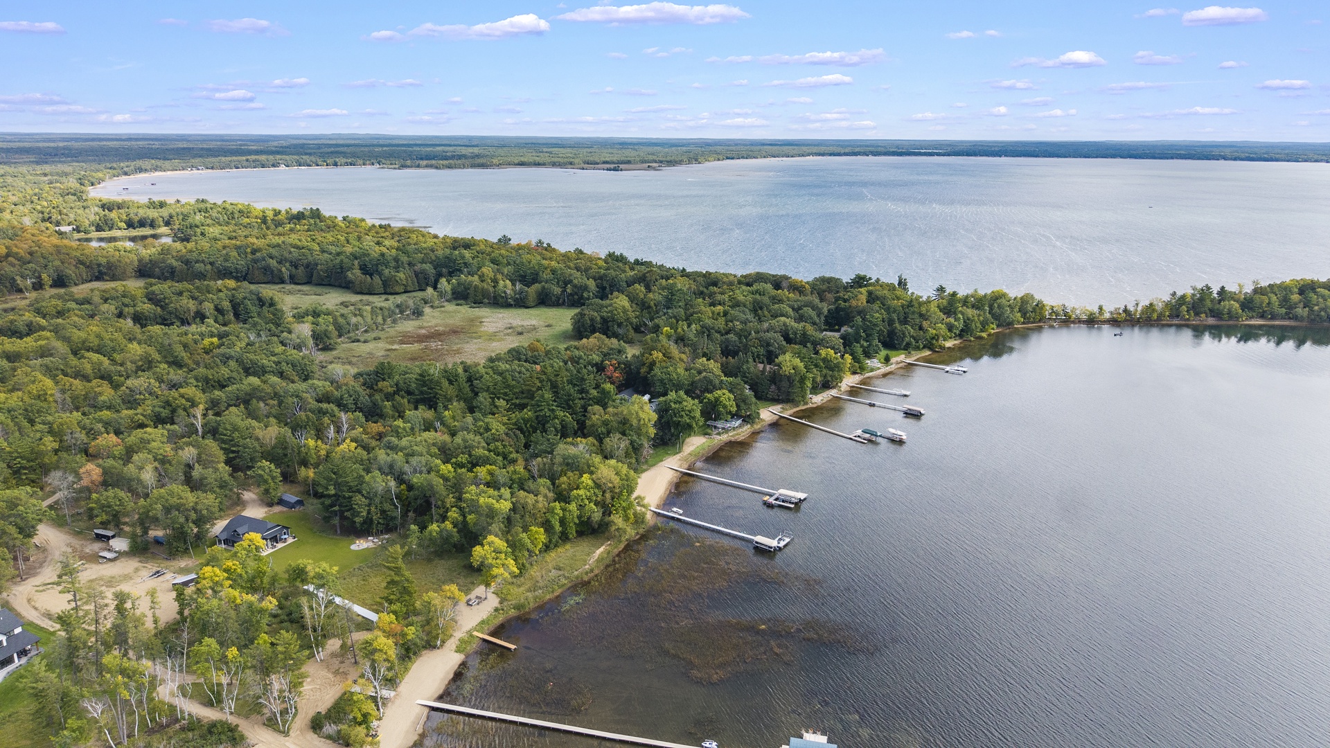 An aerial view of the waterfront property showcasing its expansive lakeside setting, private docks, and serene natural surroundings.