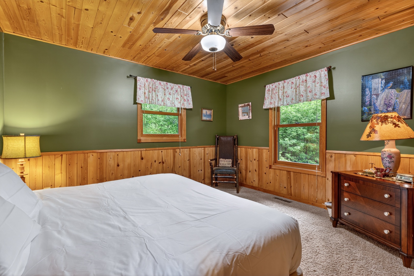 Unwind in your peaceful bedroom with natural wood accents, soft lighting, and views of lush greenery—your cozy retreat awaits after a day of adventure.