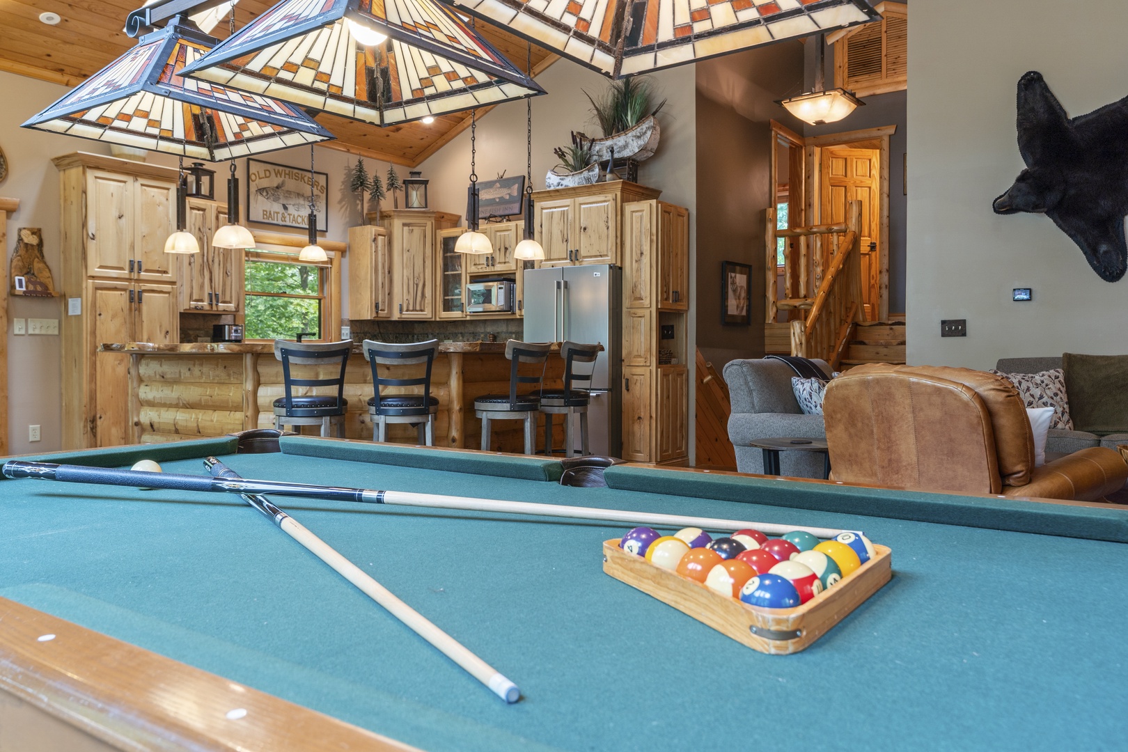 Challenge friends to a game of pool while enjoying the cabin's open-concept living, complete with rustic wood finishes and cozy seating areas just steps away.