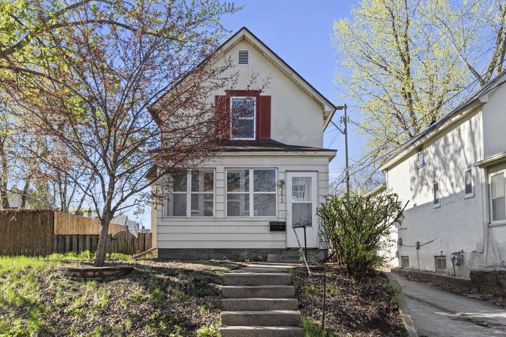 Charming two-story Minneapolis home with enclosed sunporch, mature trees, and easy street parking — a true urban retreat in a quiet residential neighborhood.