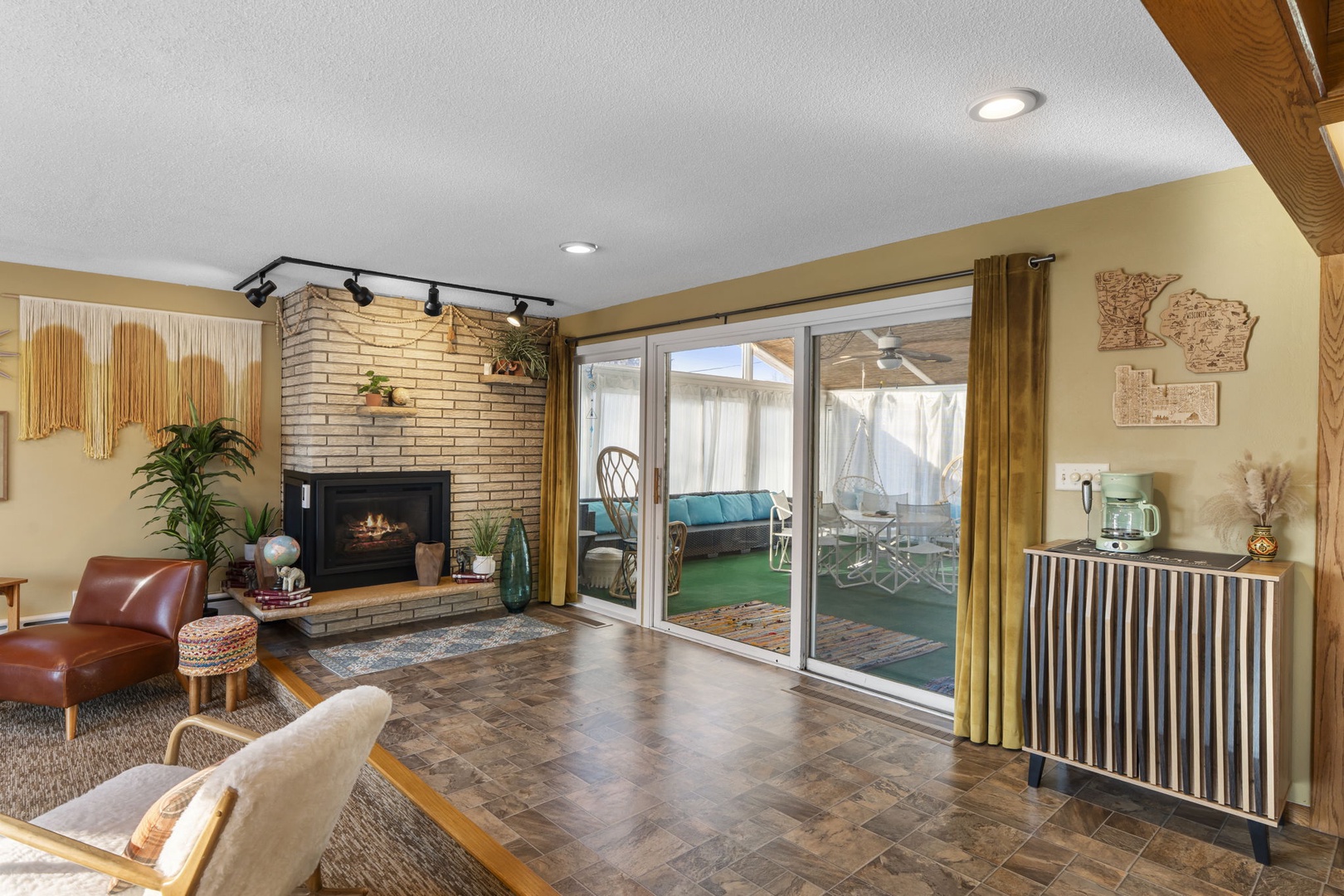 Unwind in your cozy living room where warm firelight meets modern comfort. Step through sliding doors to your private patio oasis.