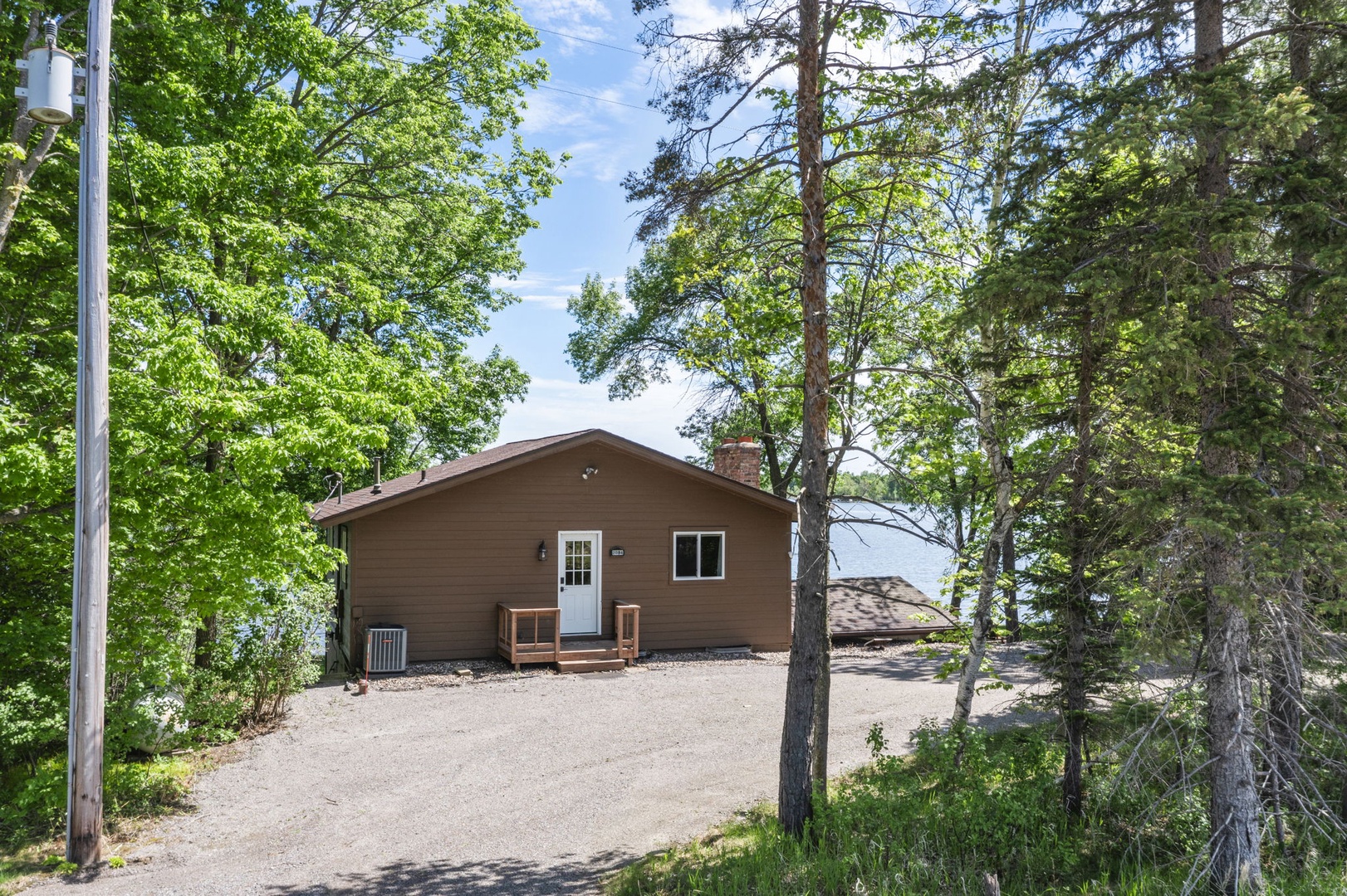 Nestled in a peaceful wooded setting, this charming lakeside cabin offers a private gravel drive and natural surroundings that promise a tranquil retreat.