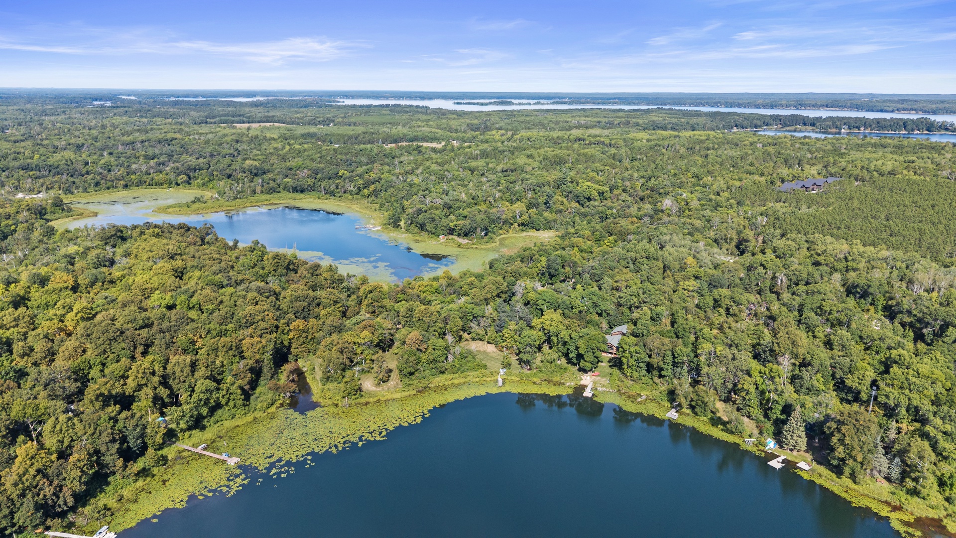Aerial view showcasing the property's pristine lakefront setting amid expansive forests and natural water features in a serene, secluded landscape.
