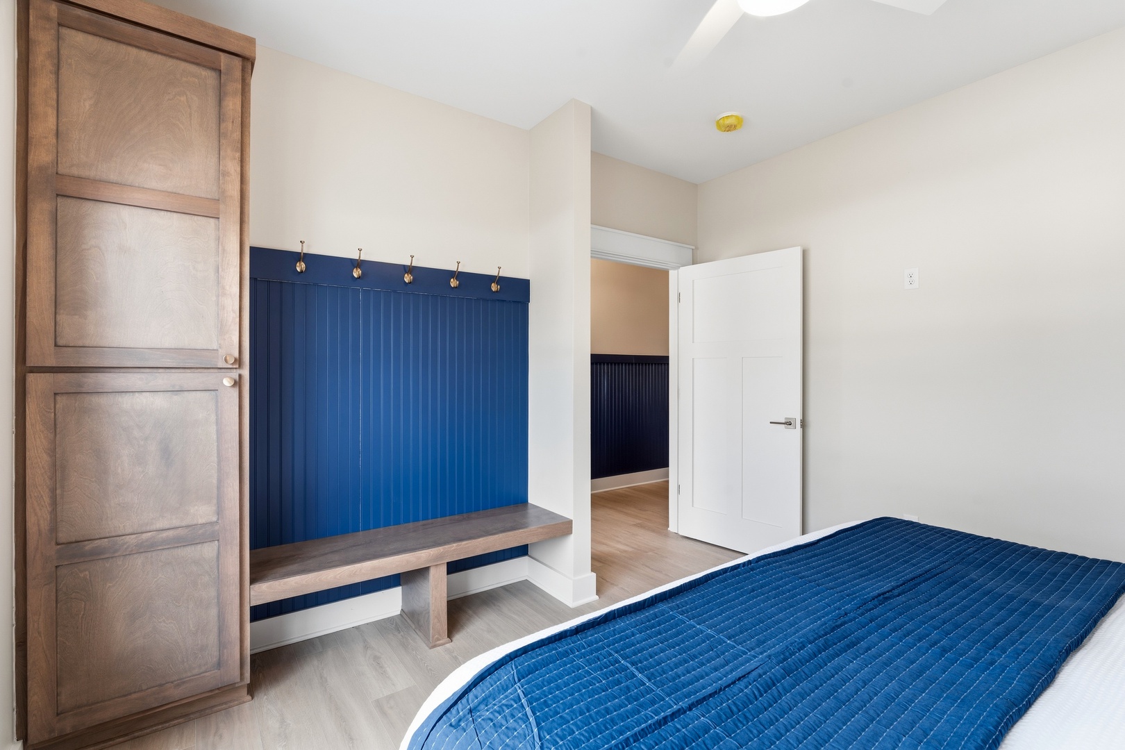 Bedroom with built-in mudroom bench wardrobe and navy blue accents