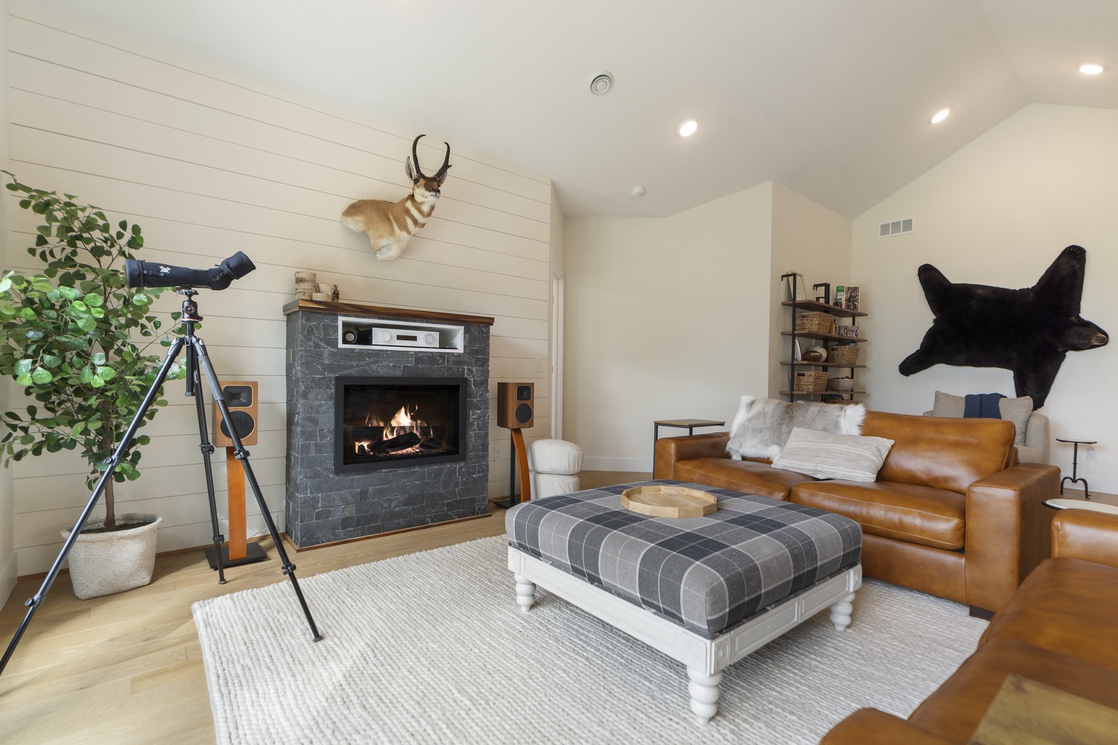 Step into your cozy retreat with rustic charm and modern comfort. Sink into the leather sofa by the glowing fireplace, where vaulted ceilings and warm wood tones create the perfect ambiance for relaxation.