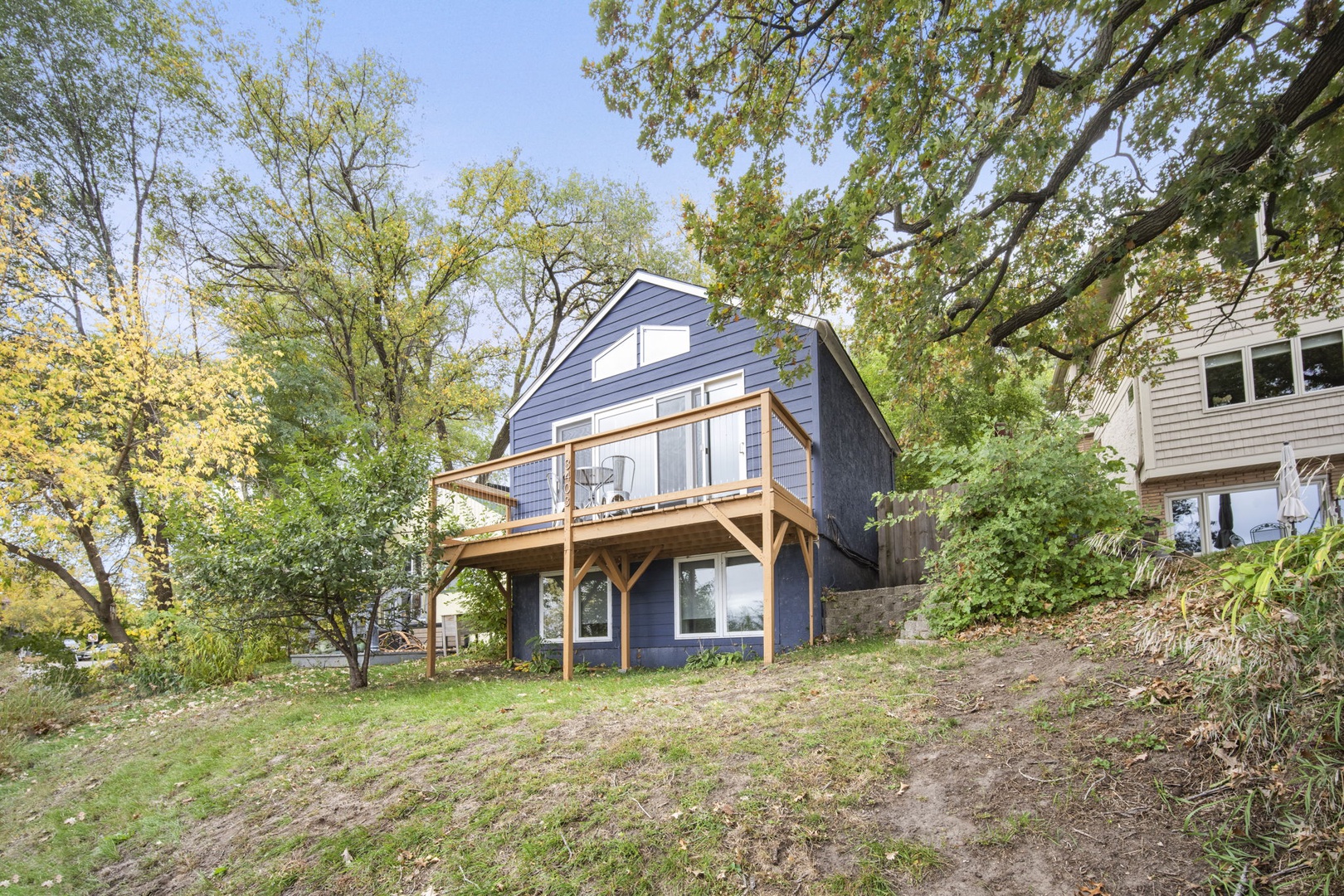 A charming two-story home with a spacious deck nestled among mature trees in a peaceful, green neighborhood—your quiet retreat awaits.