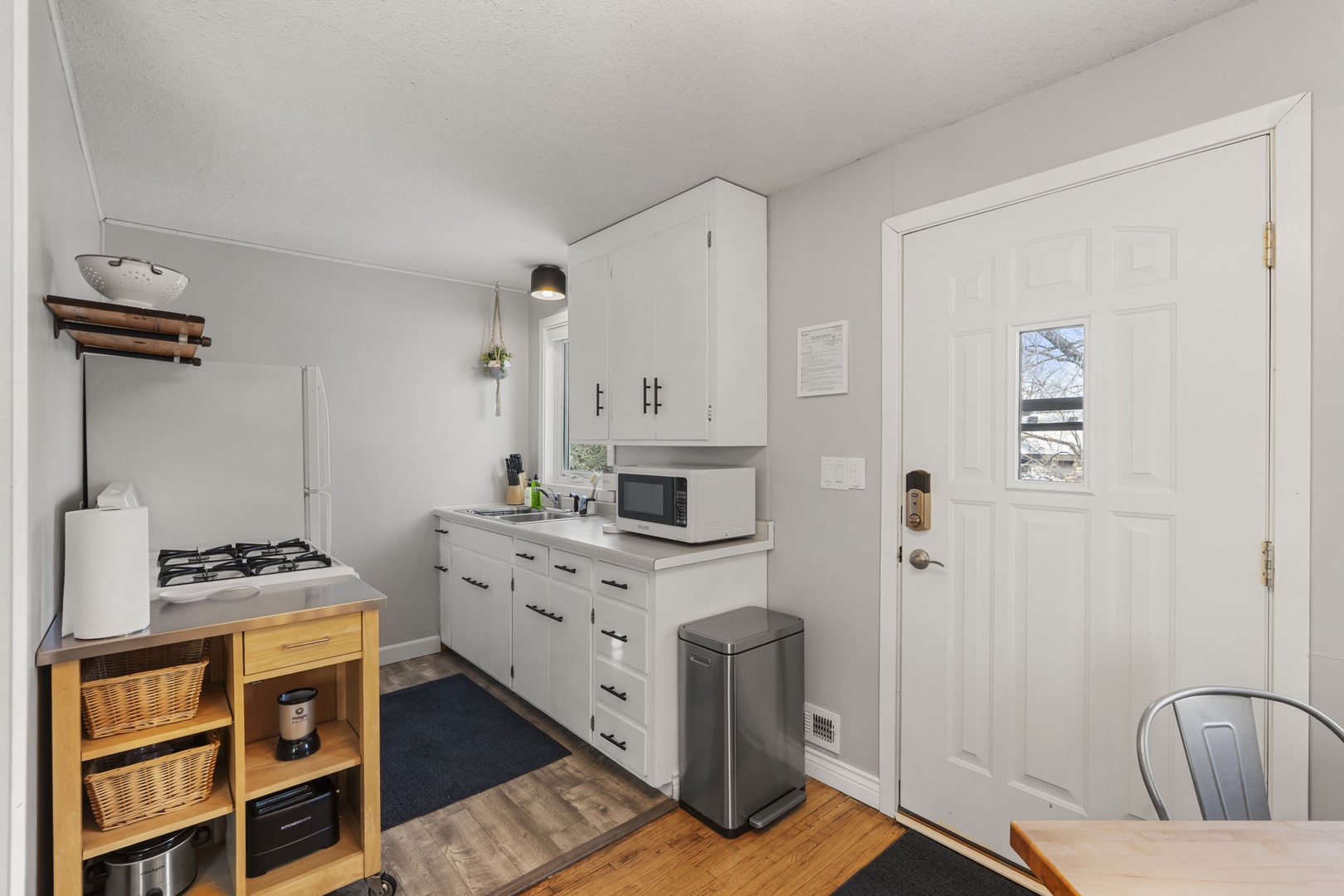 20 — Upper Kitchen with White Cabinets Coffee Station and Back Door Access