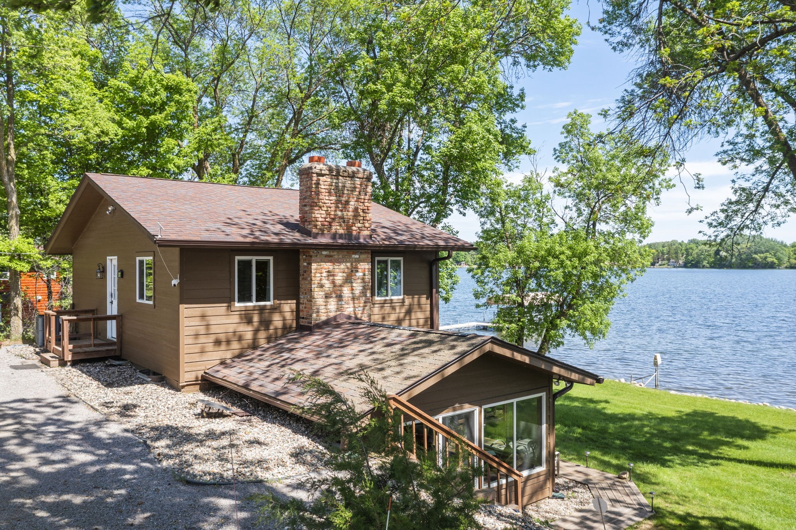 Lakefront property nestled among mature trees with direct waterfront access and serene surroundings, ideal for a peaceful getaway.