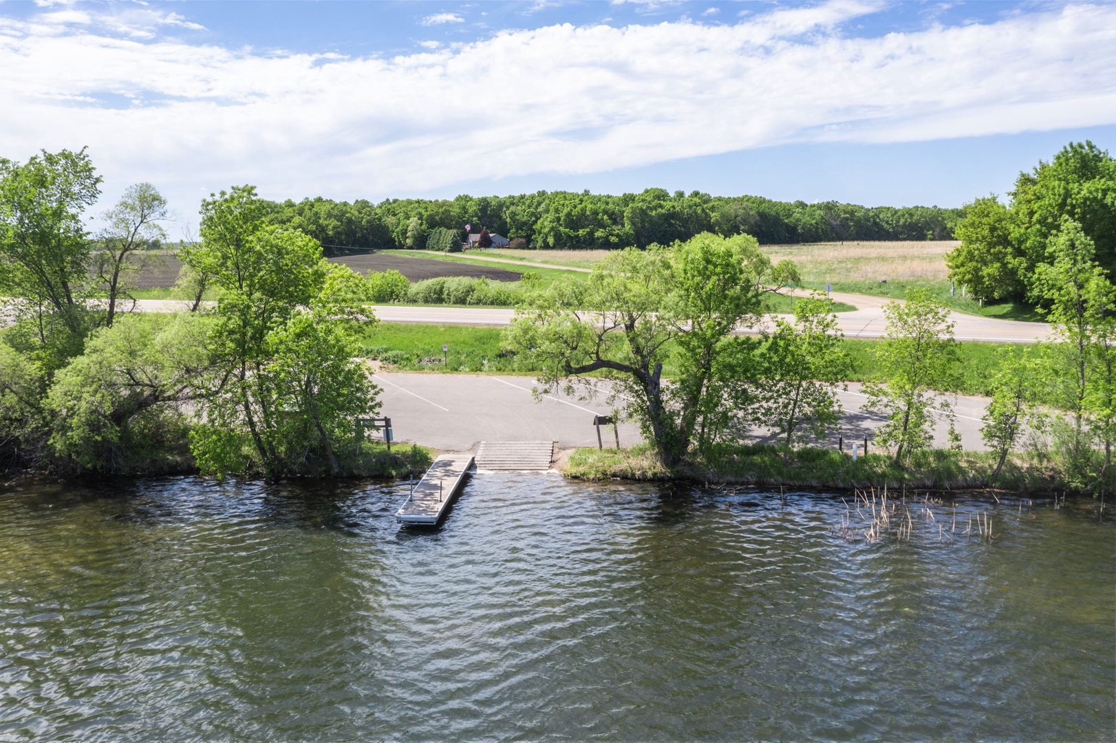 The property features nearby lakefront access with a private dock, surrounded by lush greenery and scenic natural landscape. Peaceful waterfront location offers serene views and outdoor recreation opportunities.