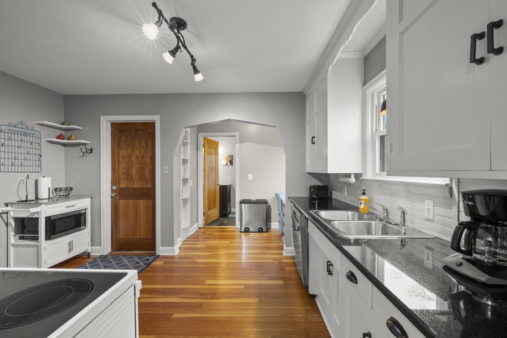 Step into a bright, spacious kitchen where you'll love preparing meals with ample counter space, modern appliances, and warm wood floors underfoot—perfect for gathering and cooking together.