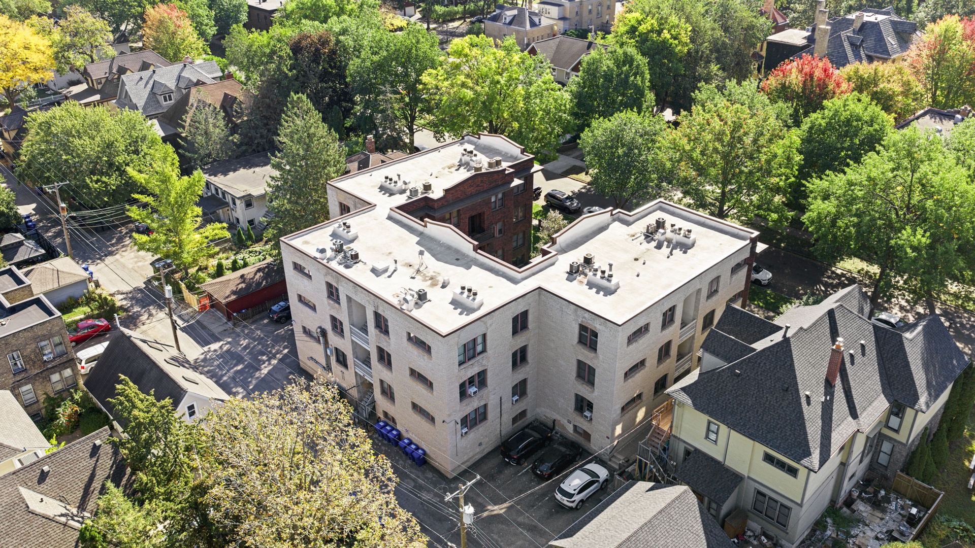 Aerial view of the property nestled in a vibrant, tree-lined neighborhood with convenient access to local streets and nearby amenities.