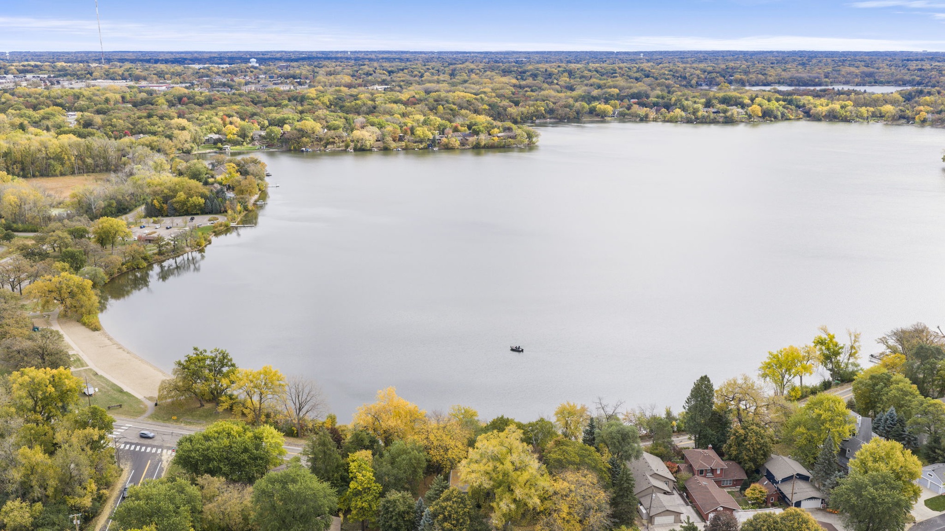 Aerial view of the property's scenic lakeside location, surrounded by mature trees and peaceful waterfront neighborhoods. A tranquil setting for a relaxing getaway.