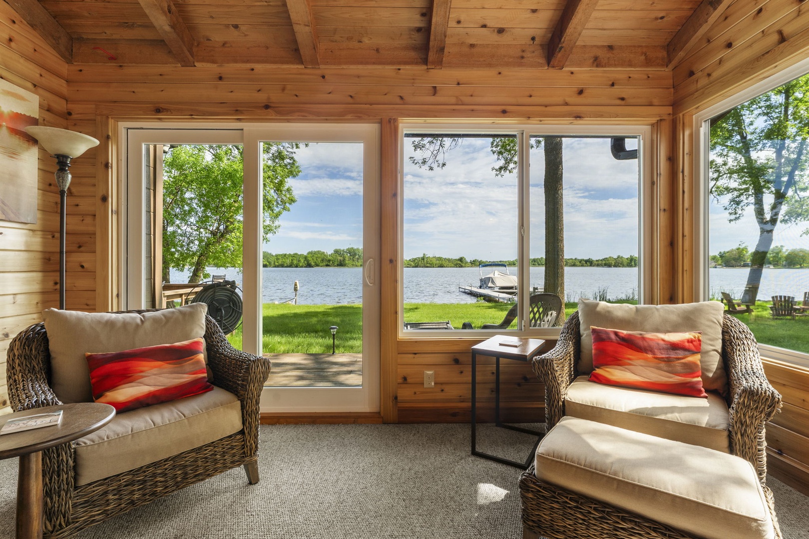 Sink into comfortable wicker seating and let the panoramic lake views wash over you through floor-to-ceiling windows—your perfect spot to unwind with morning coffee or afternoon reading.