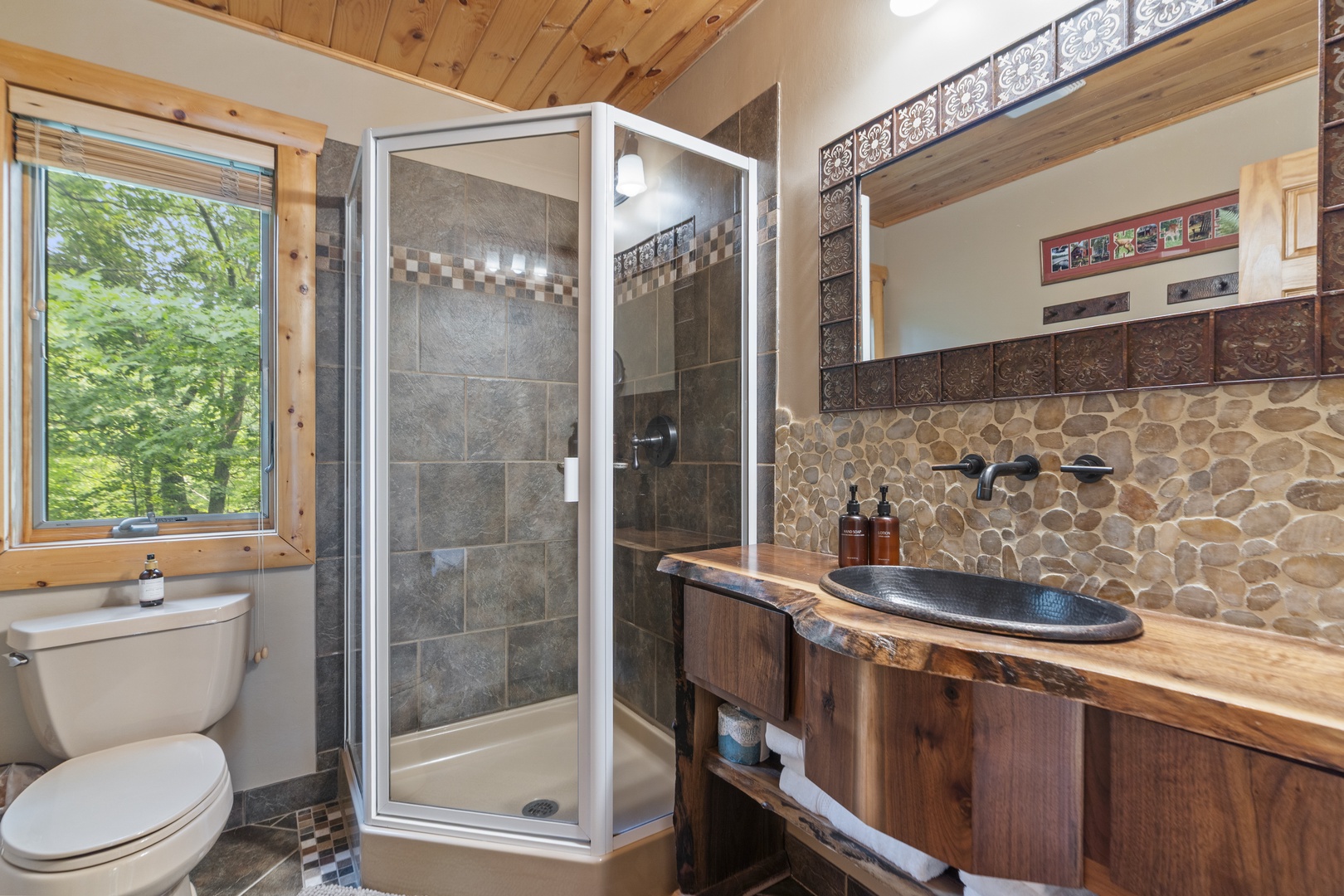 Your private retreat features warm wood tones and natural stone accents that create a spa-like atmosphere. Sunlight from the window brings the forest closer as you unwind.