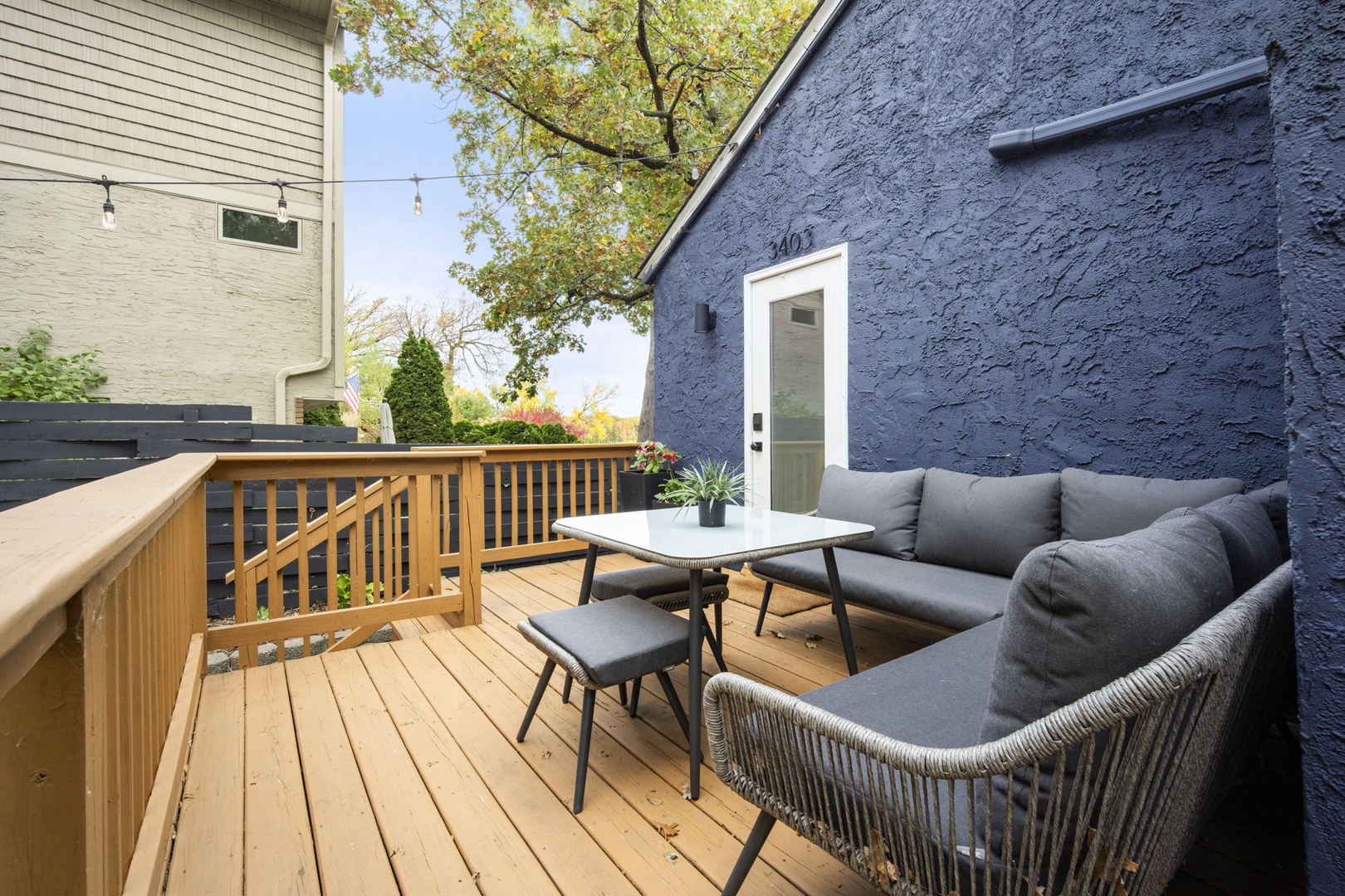 Your private deck awaits with plush seating and warm wood tones, perfect for morning coffee or sunset conversations beneath leafy branches.