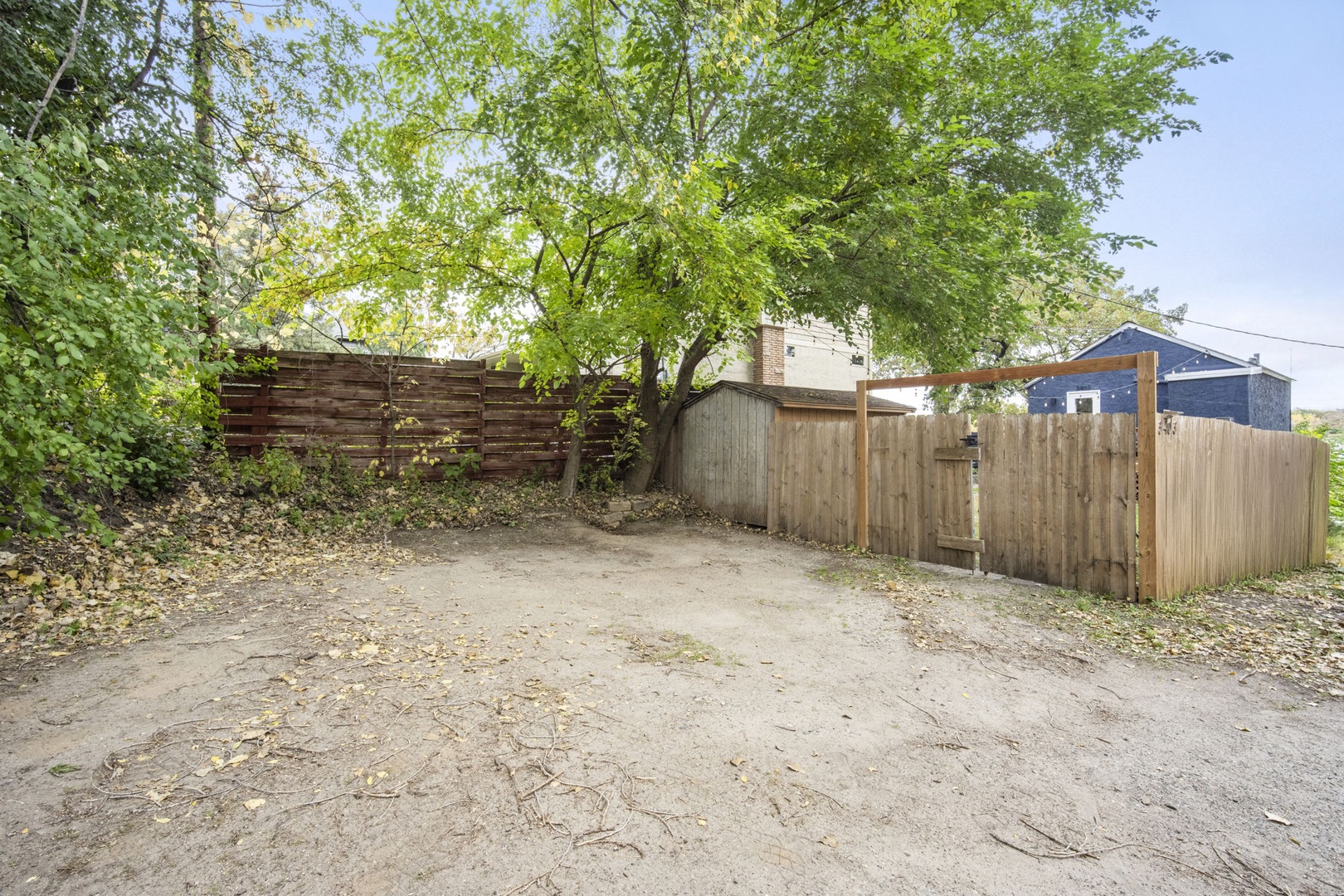 Private parking area with mature shade trees and secure fencing provides convenient arrival and departure access at this property.