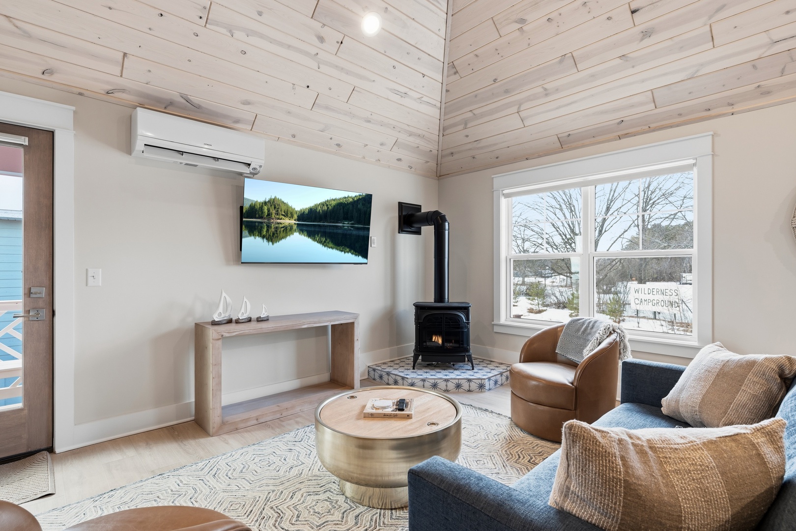 Cozy living room with wood stove smart TV and lake views