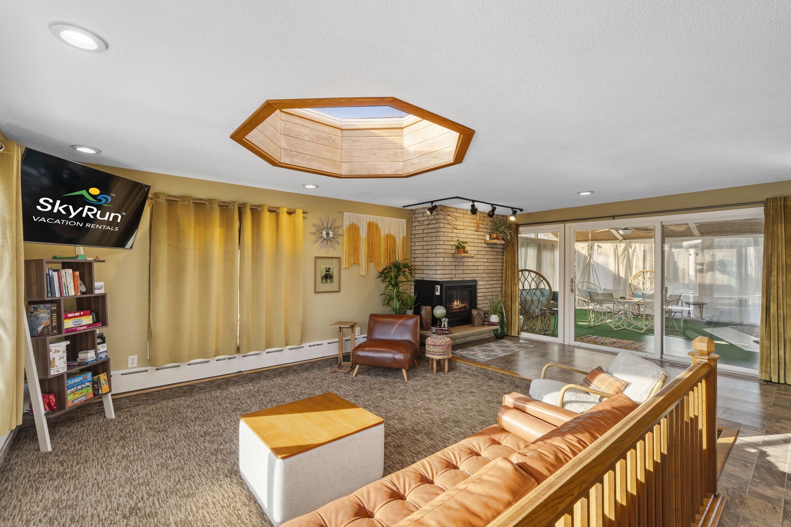 Relax in your spacious living area with cozy seating, warm fireplace, and stunning skylight overhead while enjoying games and books.