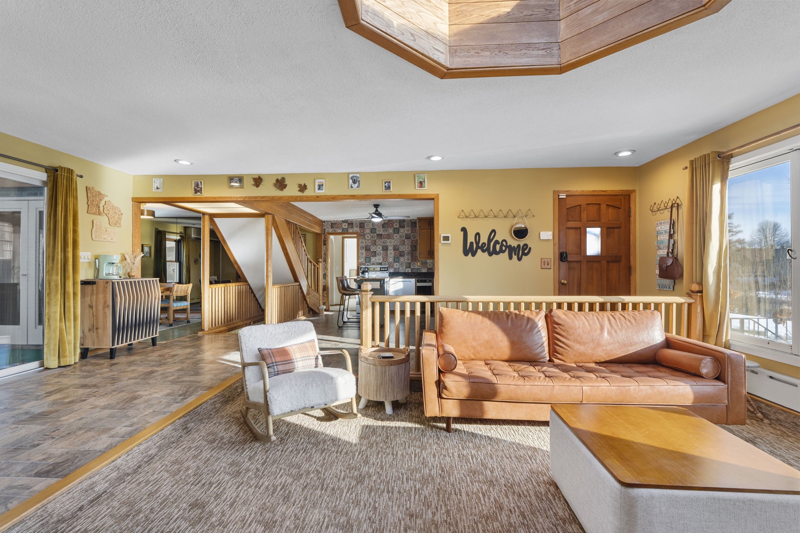 Settle into rich leather seating in your inviting open-concept living space, where warm wood tones and thoughtful design create the perfect atmosphere for relaxation.