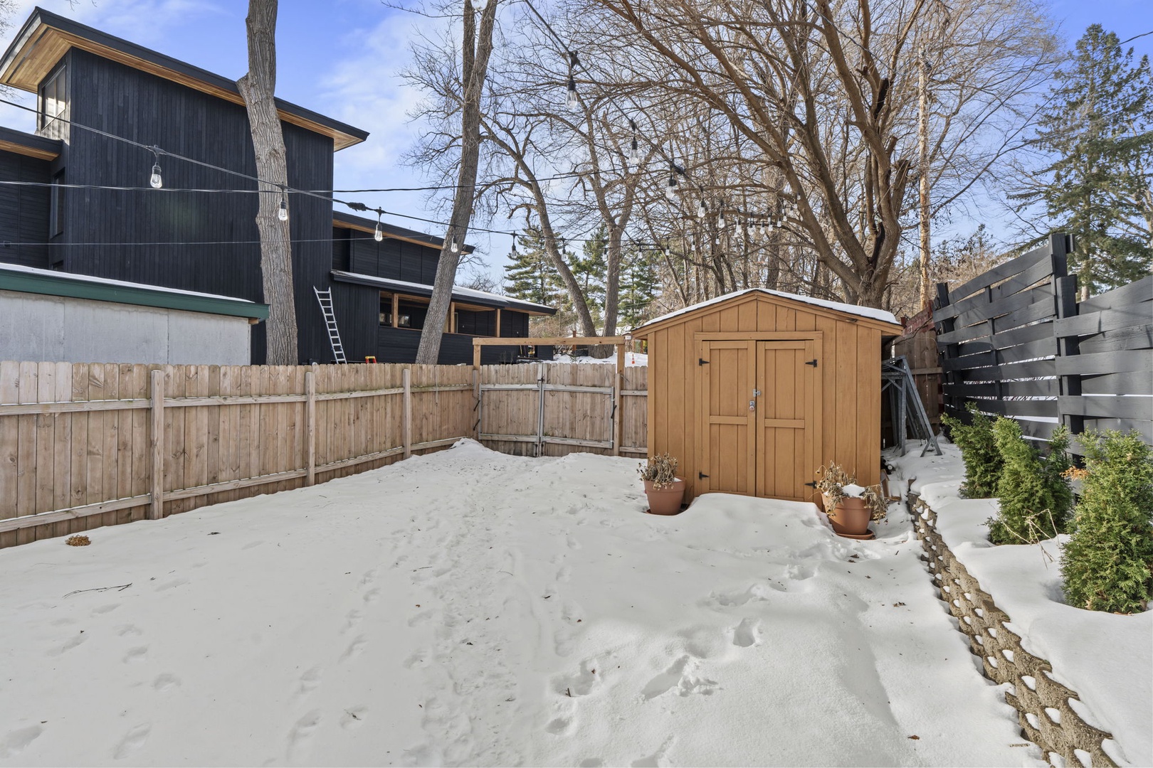Modern rental property featuring a private winter backyard with storage shed and fenced outdoor space.